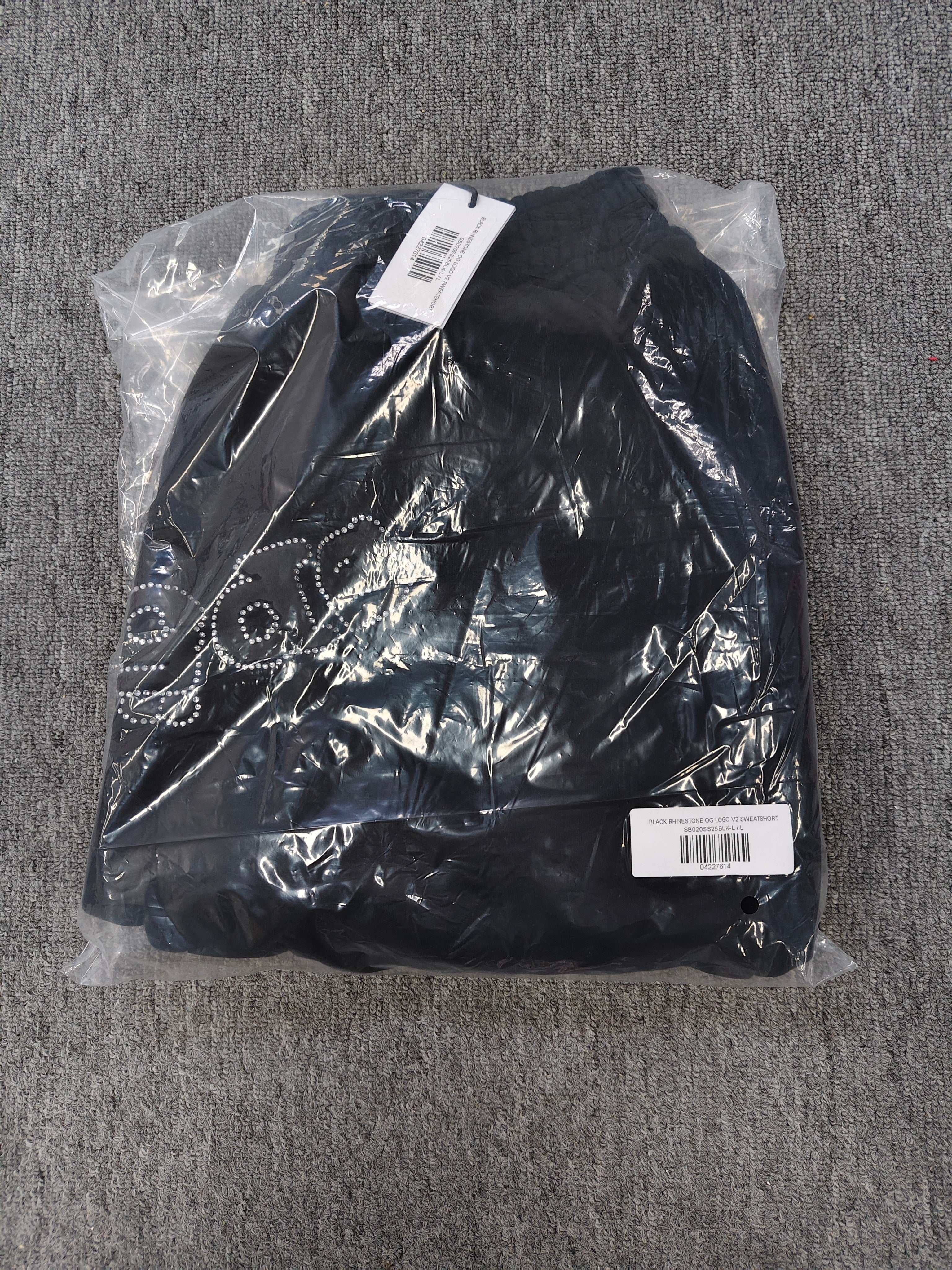 black Sp5der shorts feature a rhinestone-embellished logo and a spider web graphic