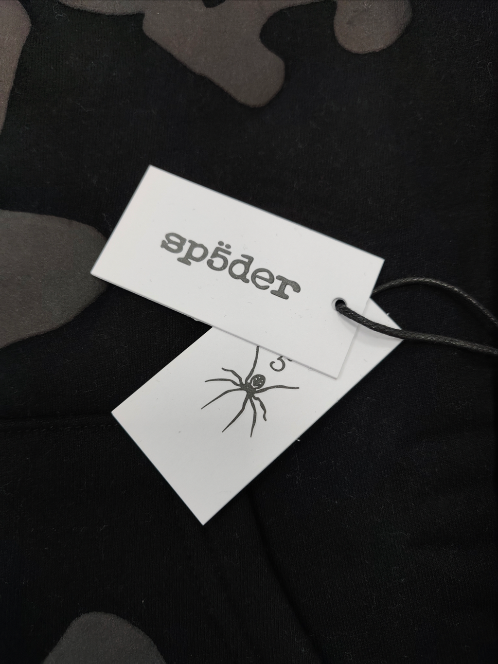 a Sp5der Reflective Beluga Hoodie in Black, featuring large reflective graphics