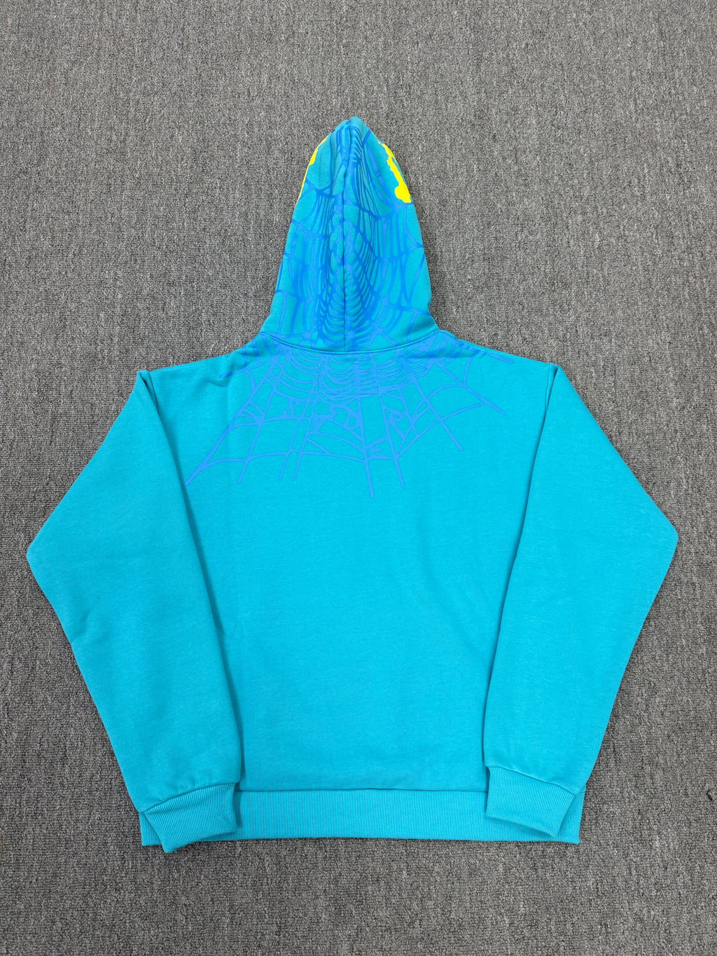 Sp5der Heavy Web Hoodie in 'Cyan' is designed with a striking blue color and a signature web-inspired graphic on the hood