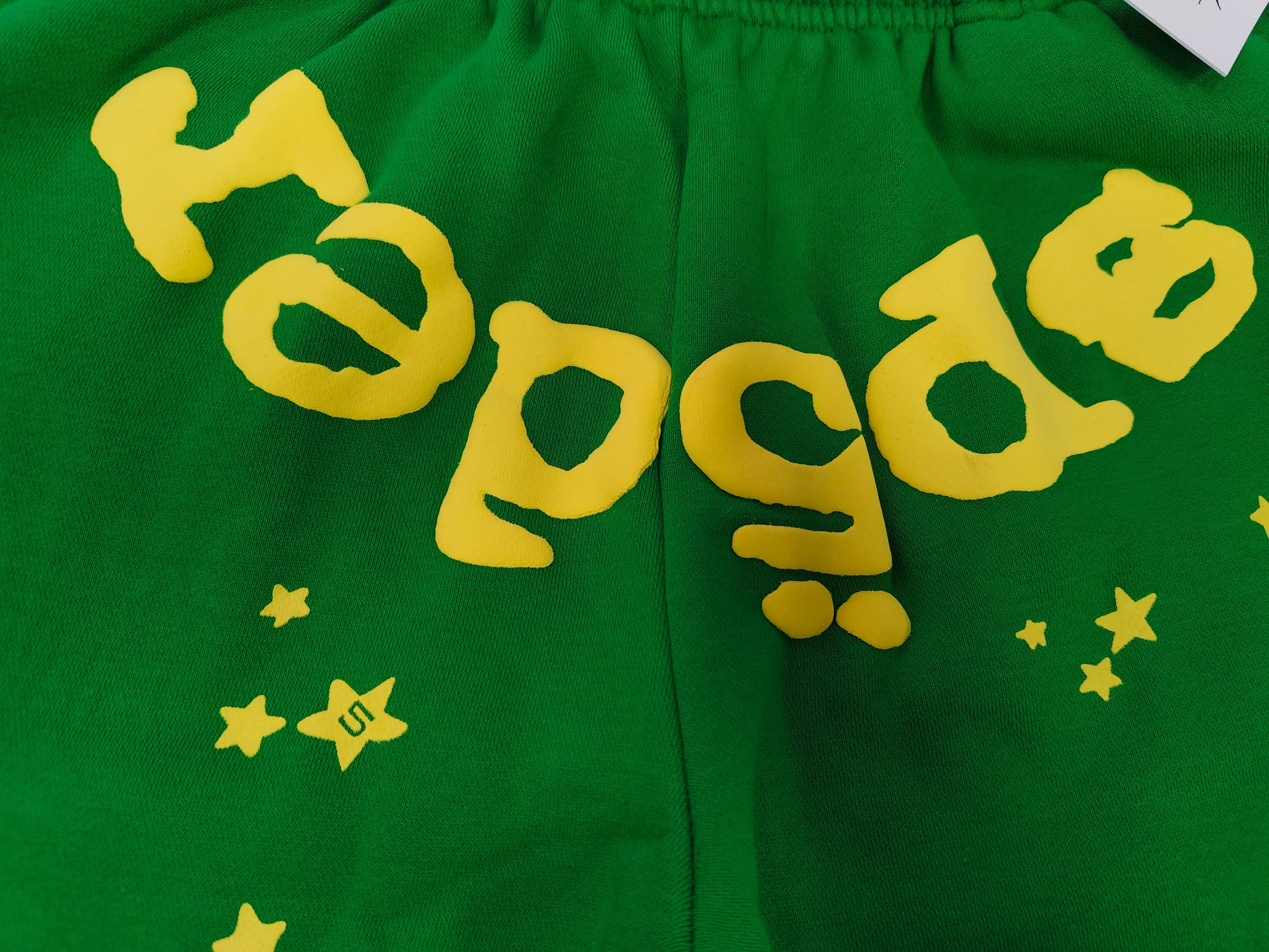 Sp5der Star OG Web V2 Sweatpants in the Slime Green colorway, featuring scattered yellow star motifs and a yellow brand graphic