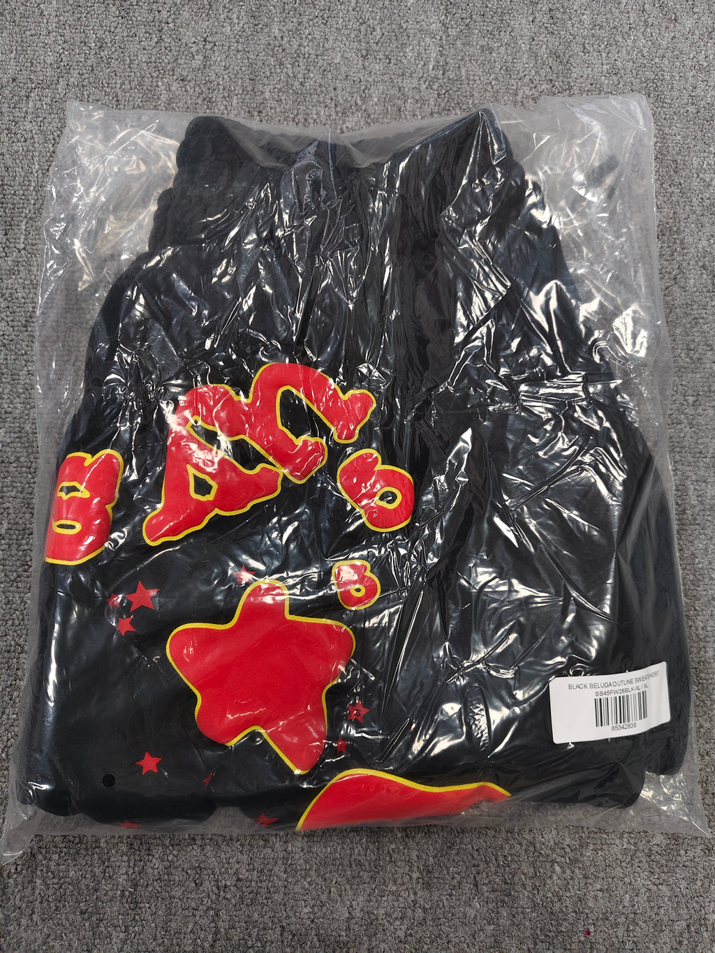 Sp5der x UY SCUTI collaboration shorts featuring bold red graphic logos on a black base