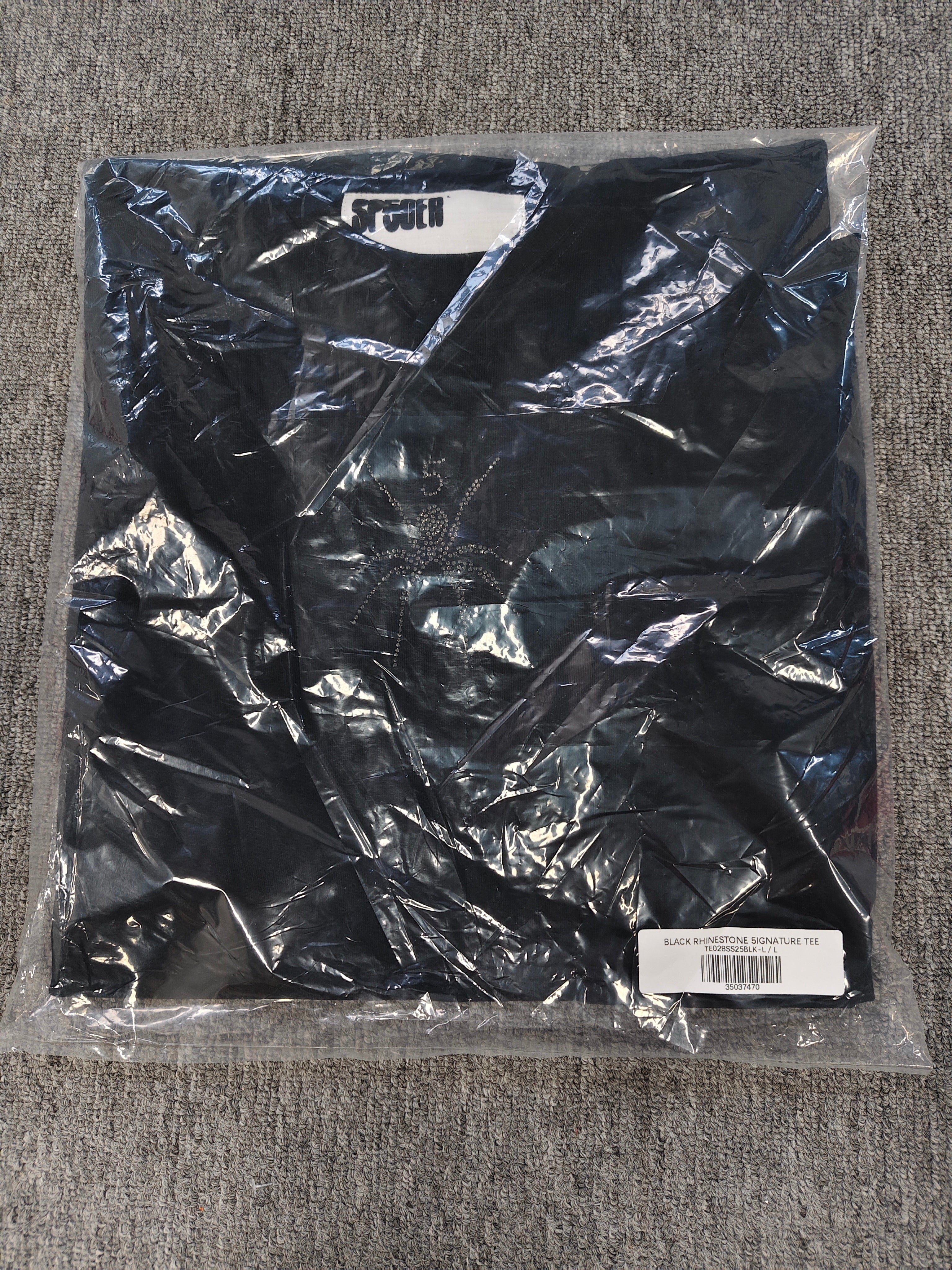 black Sp5der TM rhinestone tee features a central spider motif constructed from sparkling rhinestones