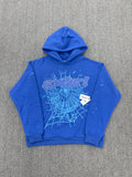 blue hoodie is a SP5DER Punk V2 model featuring a prominent spider-web graphic with rhinestone embellishments