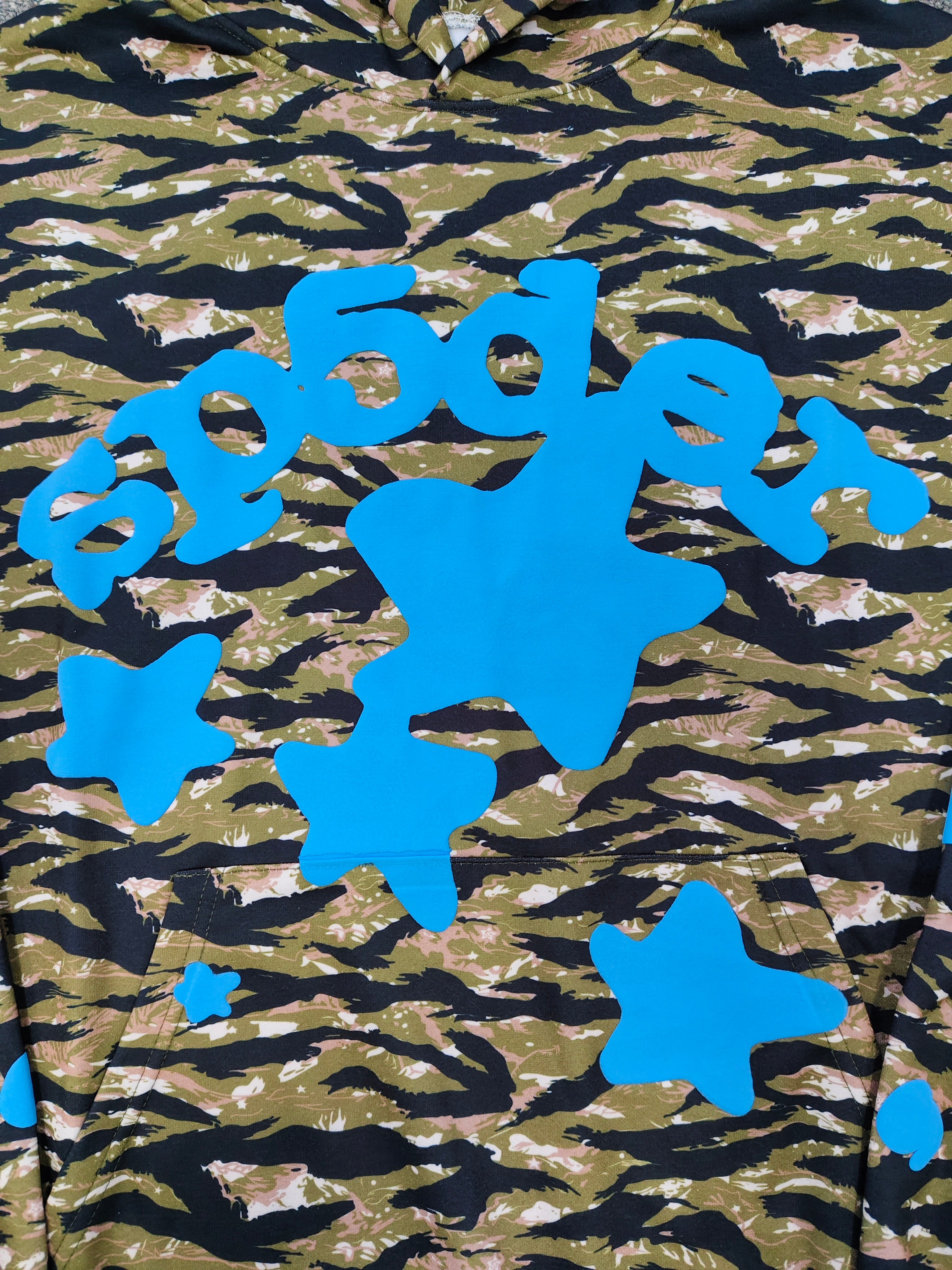 Sp5der Beluga hoodie features a distinct tiger camo pattern and vibrant blue star graphics