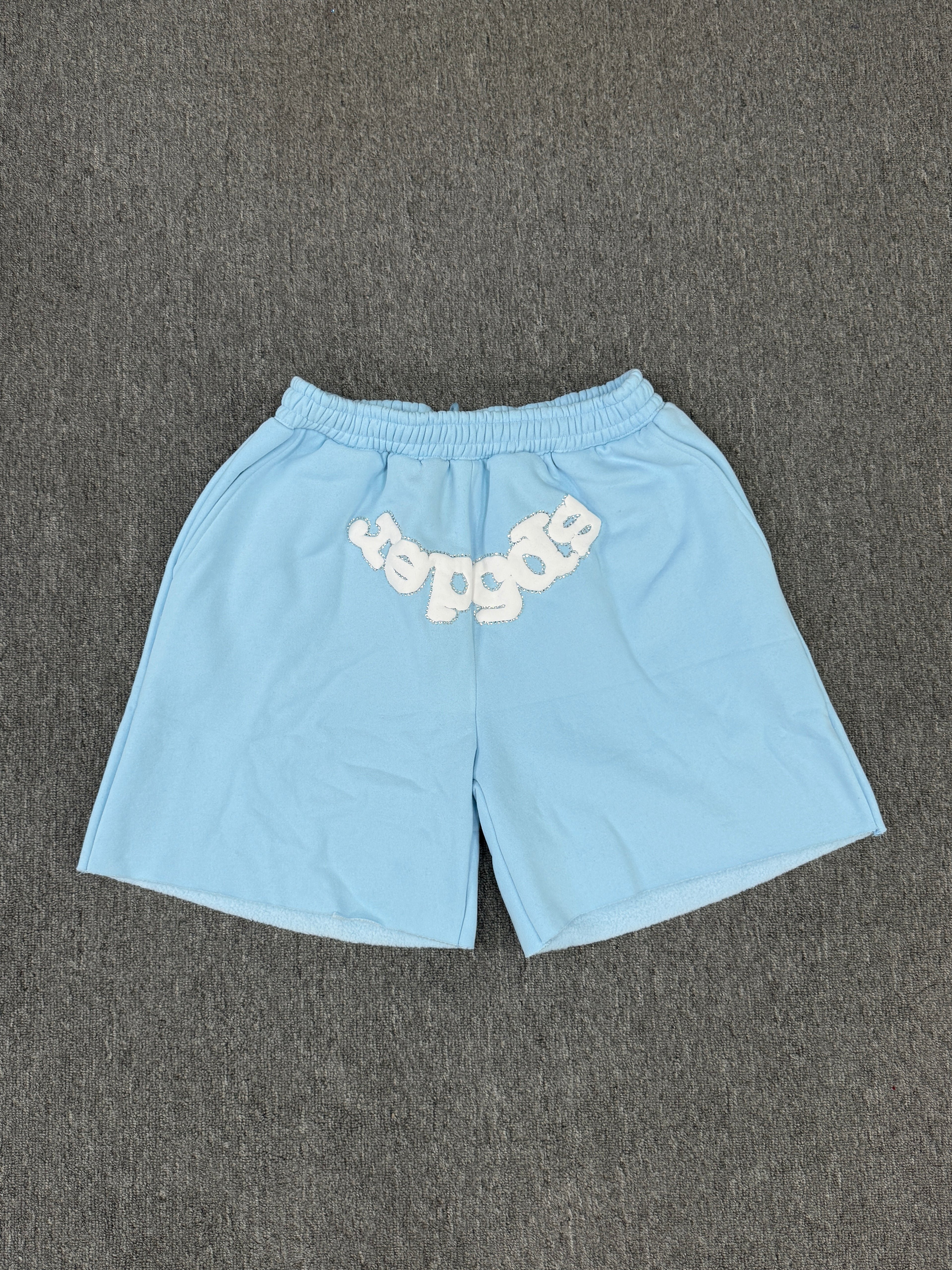 Sp5der OG Web Sweatshorts in Sky Blue, featuring the brand's signature webbed logo graphic on the front