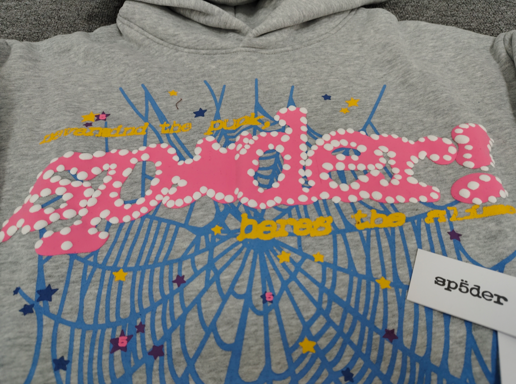 grey Sp5der hoodie features a prominent pink rhinestone graphic and a blue spiderweb design