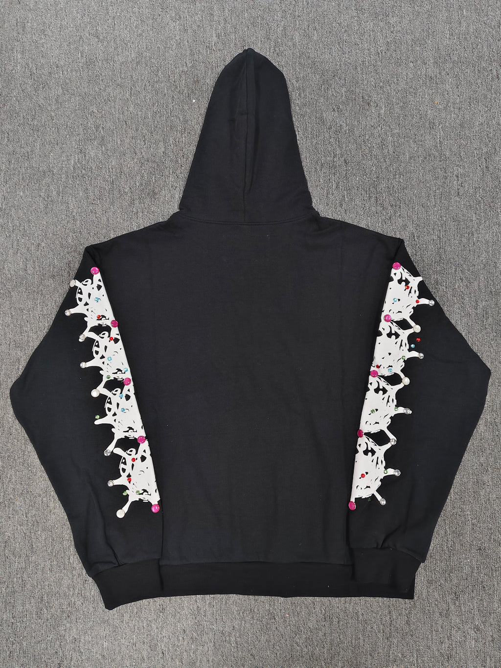 a black Sp5der Stone Hoodie featuring rhinestone embellishments along the sleeves