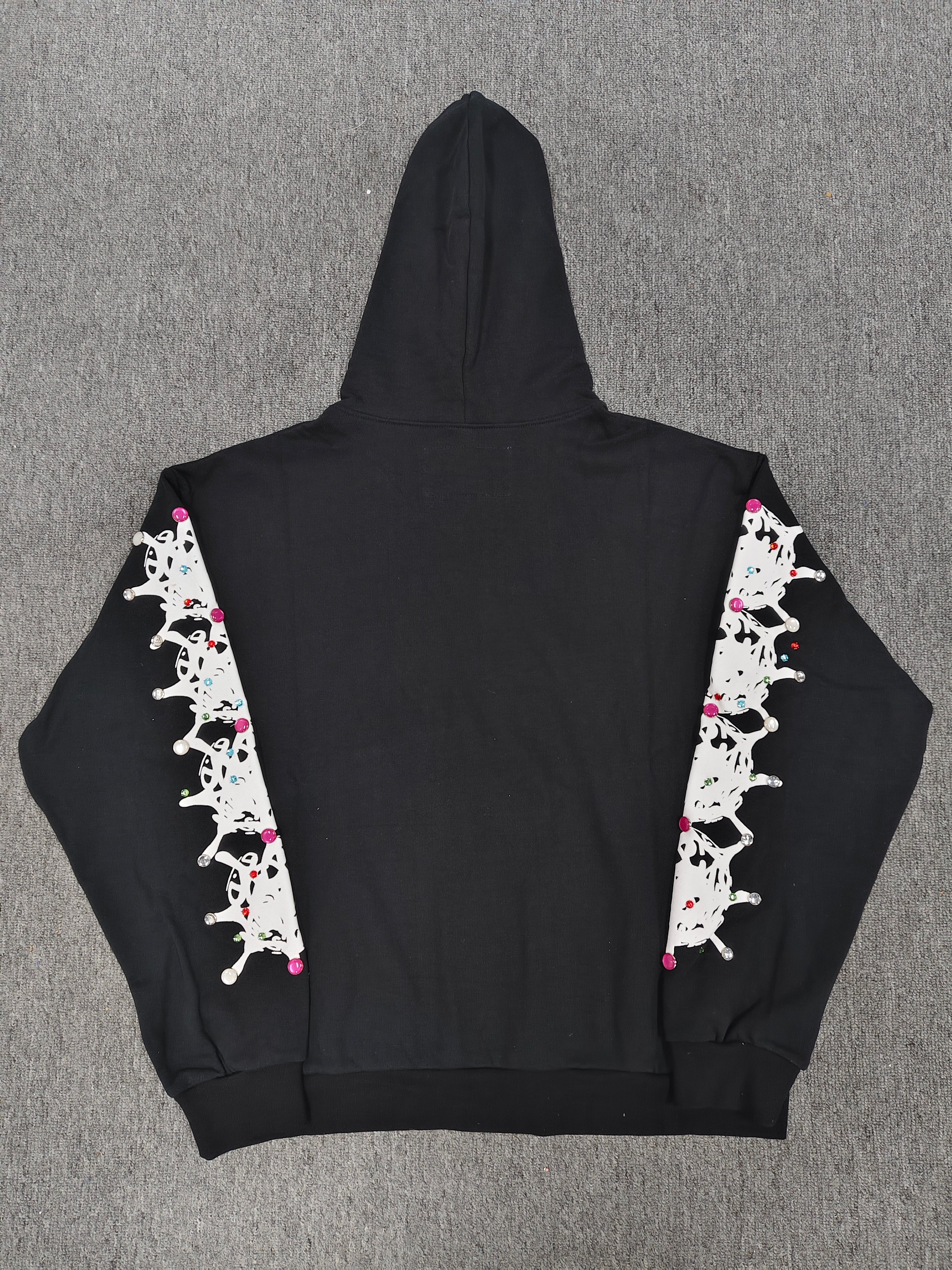 a black Sp5der Stone Hoodie featuring rhinestone embellishments along the sleeves