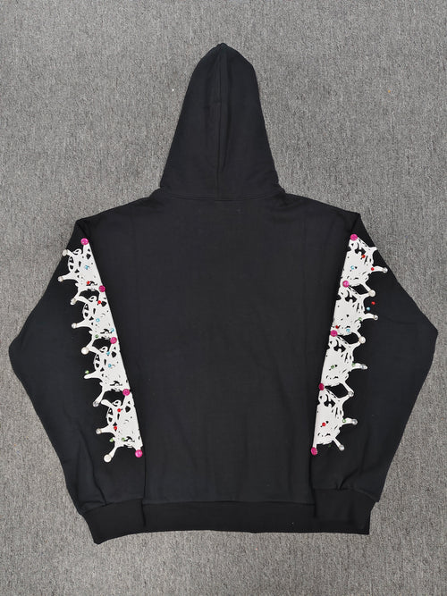 a black Sp5der Stone Hoodie featuring rhinestone embellishments along the sleeves
