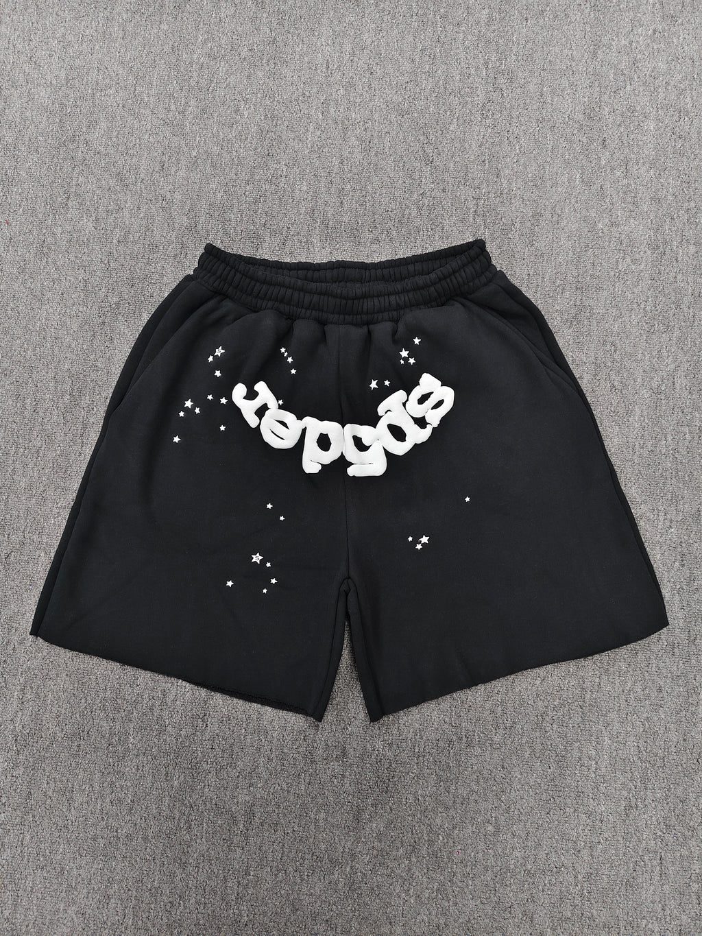 black Sp5der OG Web Logo sweatshorts featuring a prominent white puff-print logo and scattered star graphics