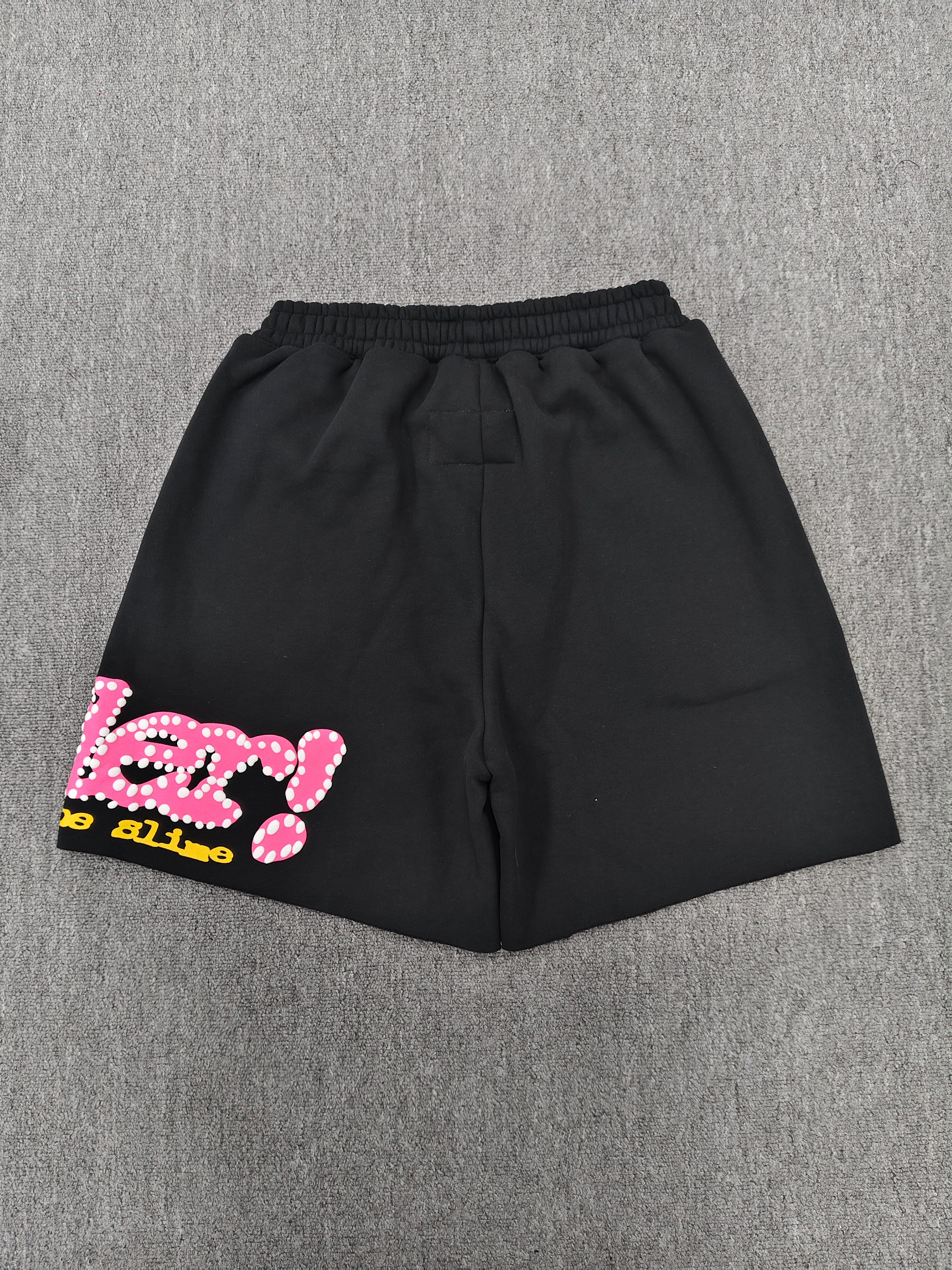 Sp5der Punk V2 shorts in black, featuring a vibrant pink logo and scattered colorful stars
