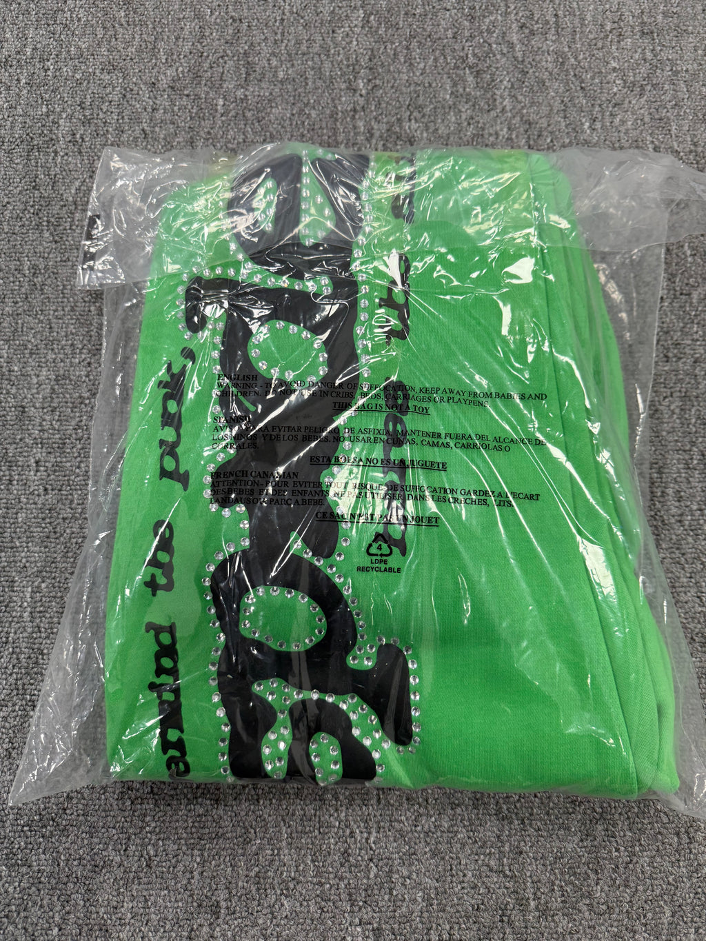 Sp5der Punk V2 Rhinestone track pants in green, featuring prominent black rhinestone-lined graphics and stars
