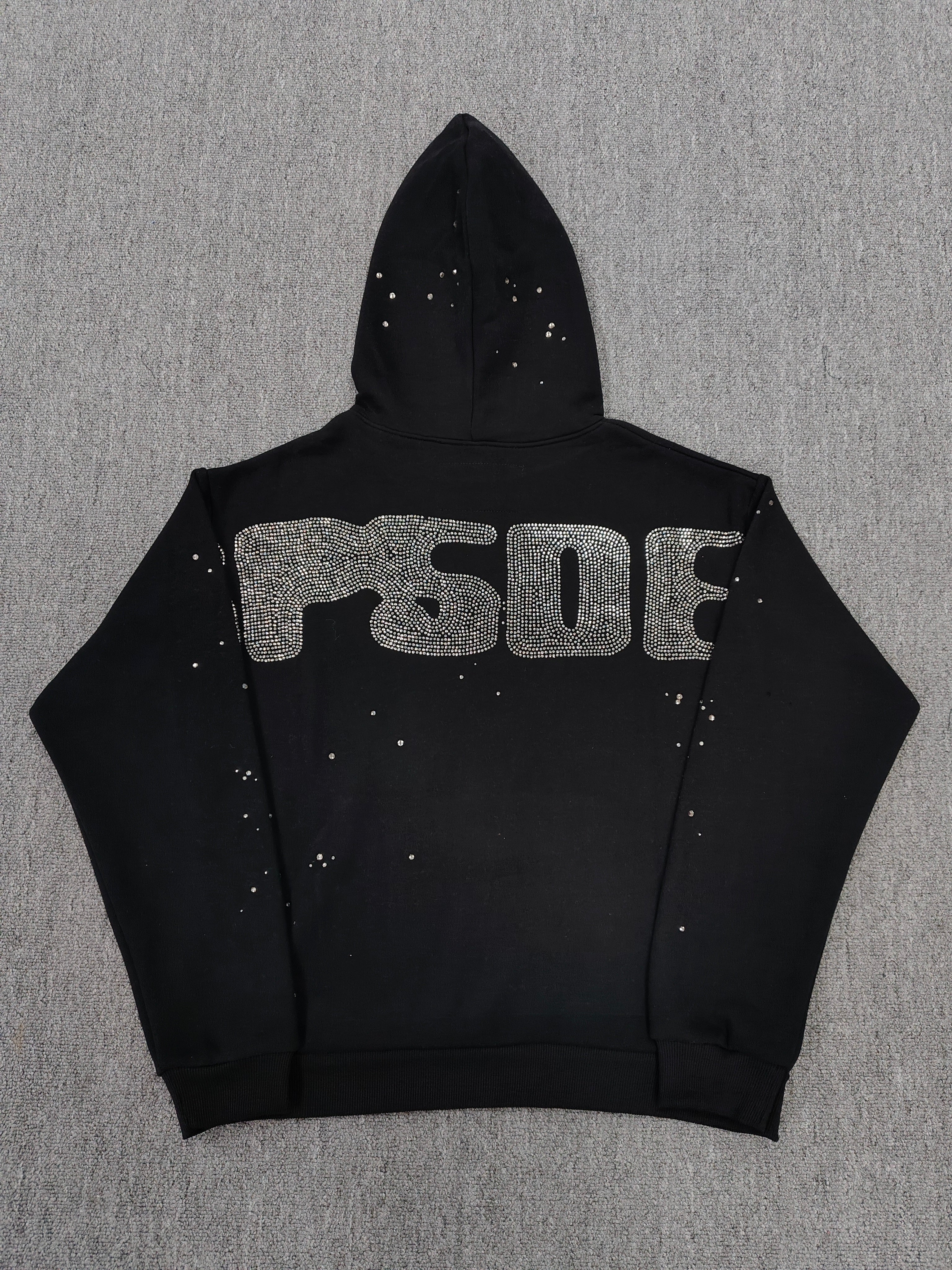 a Sp5der Rhinestone Silk Hoodie in black, featuring a prominent rhinestone web graphic on the front