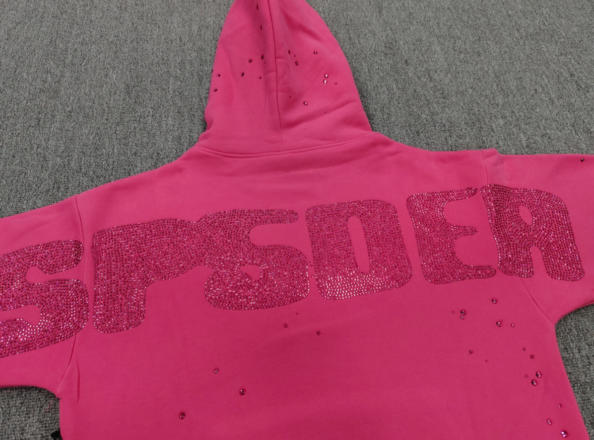 Sp5der Rhinestone Silk Hoodie in pink featuring a prominent rhinestone spiderweb graphic