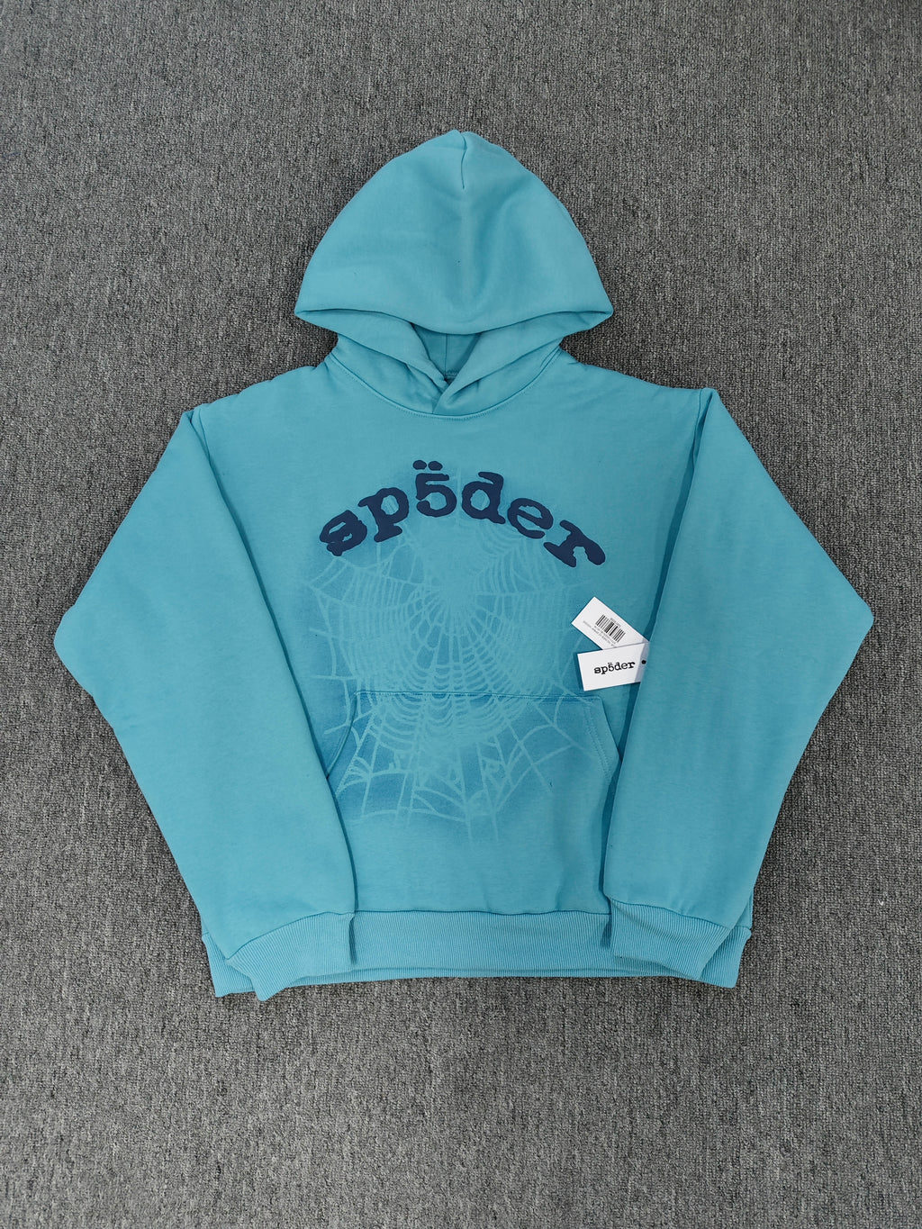light blue Sp5der OG Web V2 Spray Hoodie features a prominent, sprayed-on navy spiderweb graphic