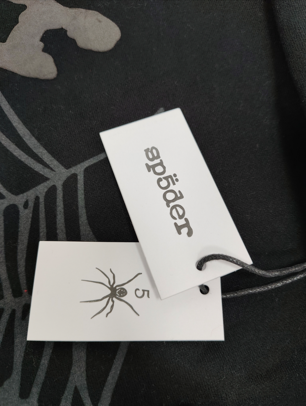 Sp5der OG Web V2 Phantom Zip Up hoodie features a black colorway with a prominent puff-printed web graphic on the front