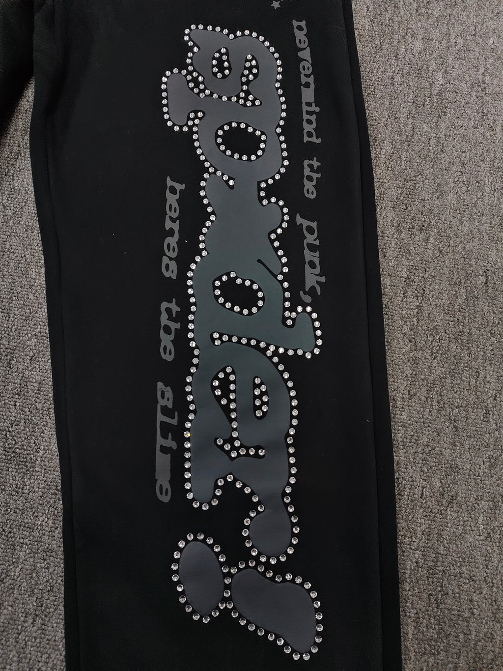 black SP5DER Rhinestone Punk V2 track pants feature rhinestone star embellishments and a rhinestone-encrusted logo