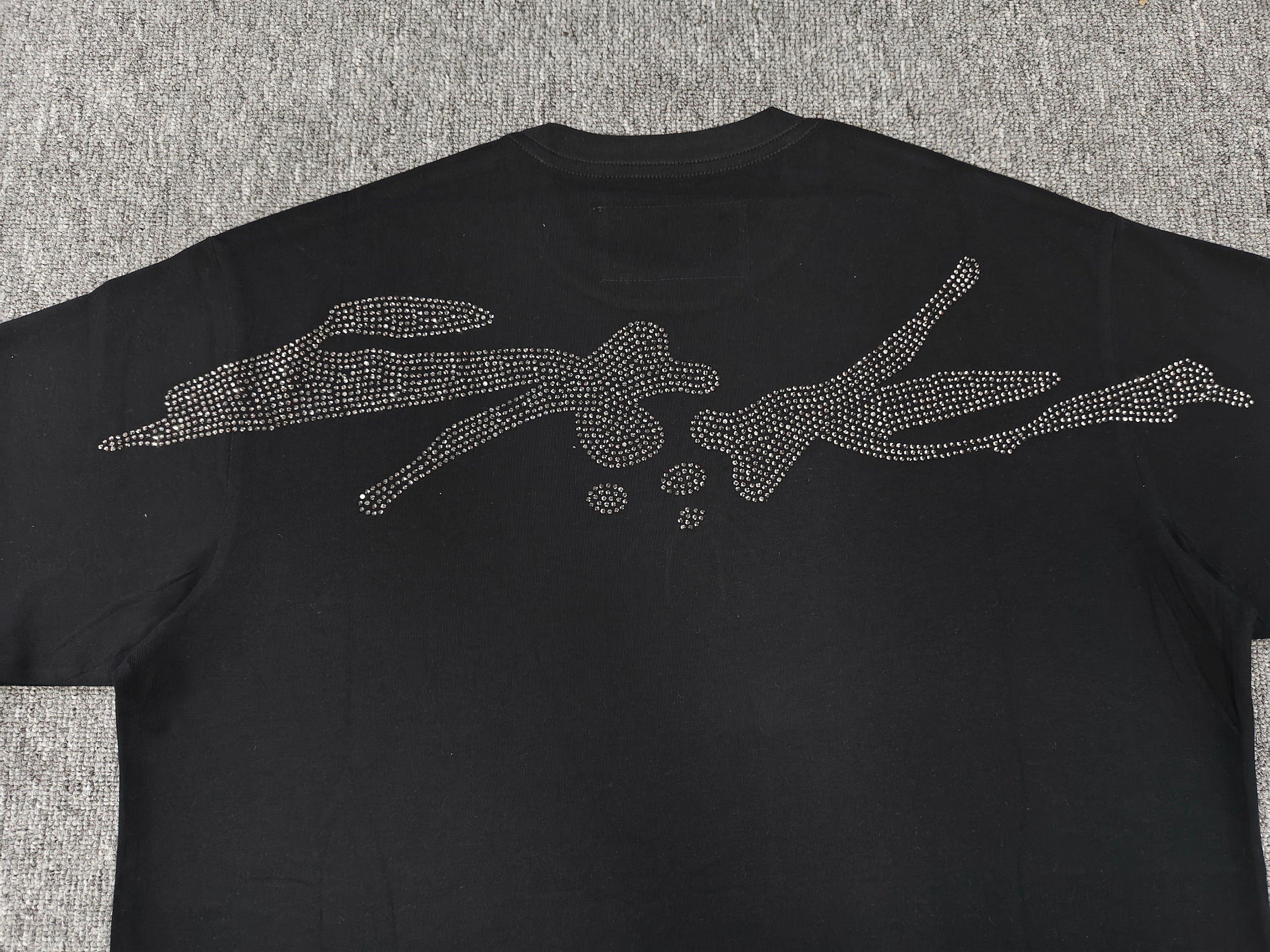 black Sp5der TM rhinestone tee features a central spider motif constructed from sparkling rhinestones