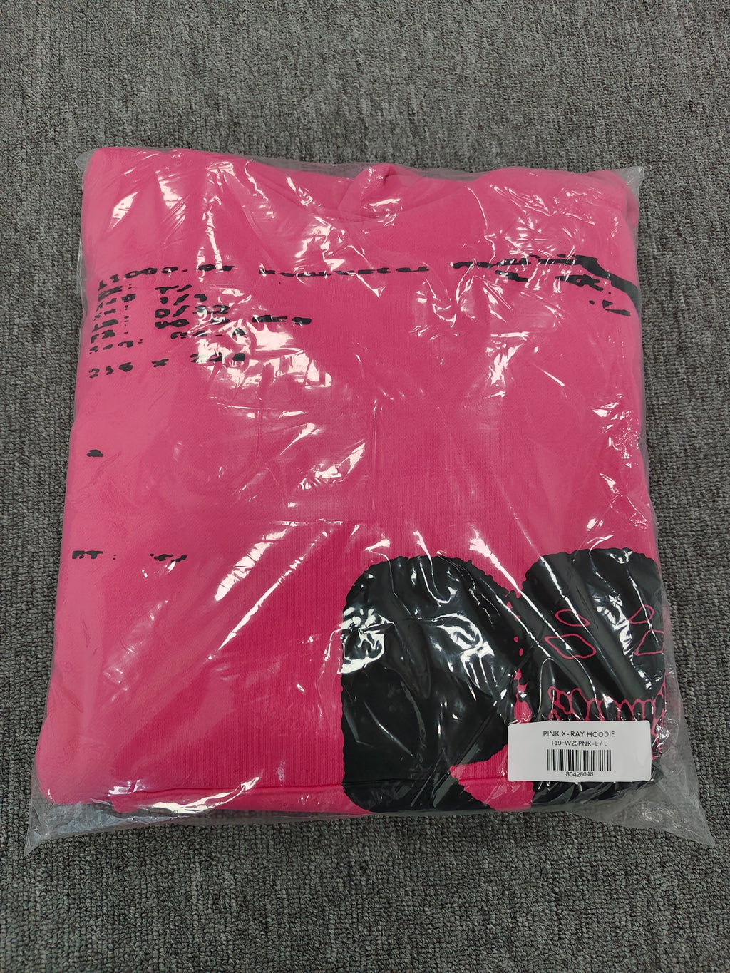 hot pink Sp5der hoodie featuring large, bold black screen-printed graphics on the front and arms.