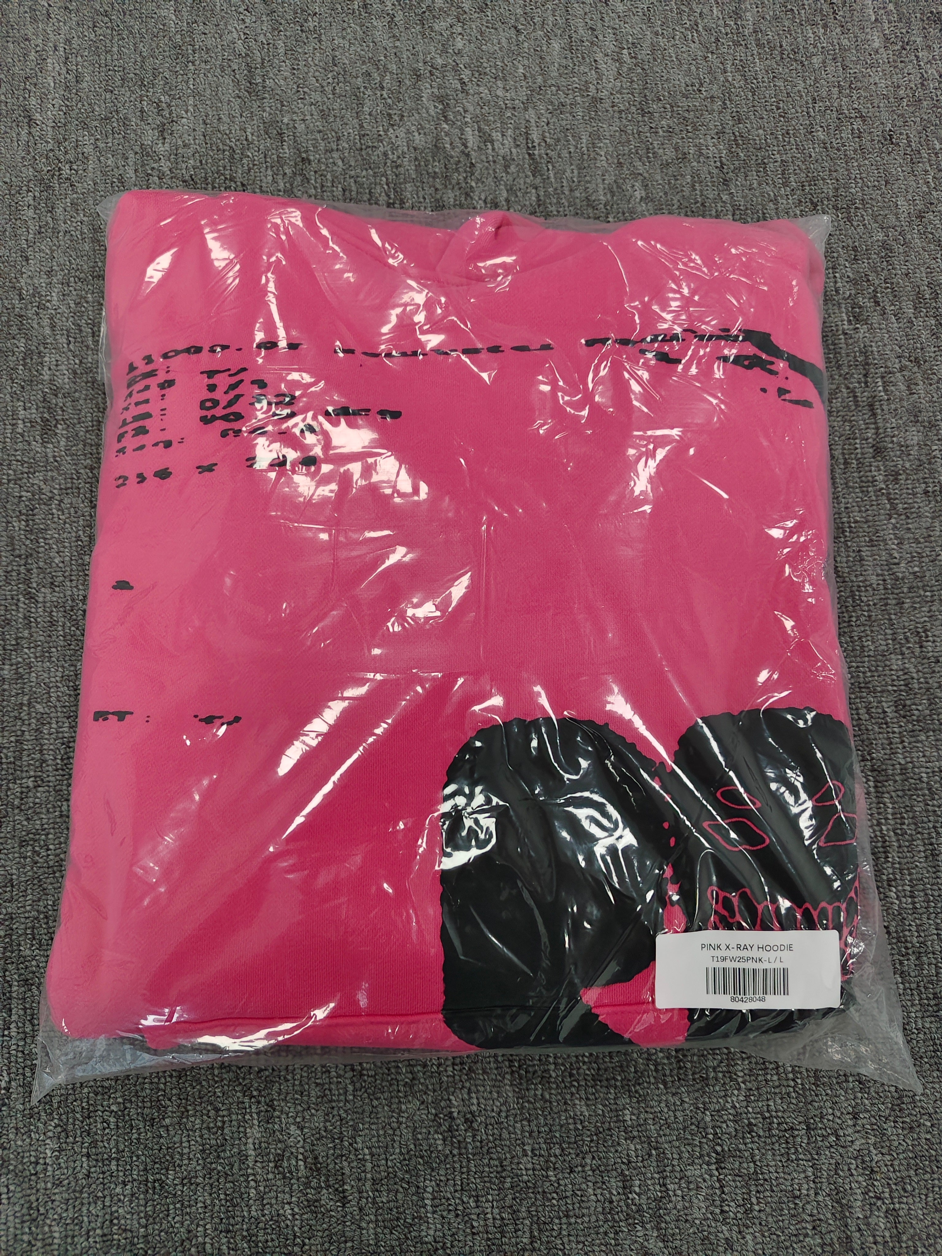 hot pink Sp5der hoodie featuring large, bold black screen-printed graphics on the front and arms.