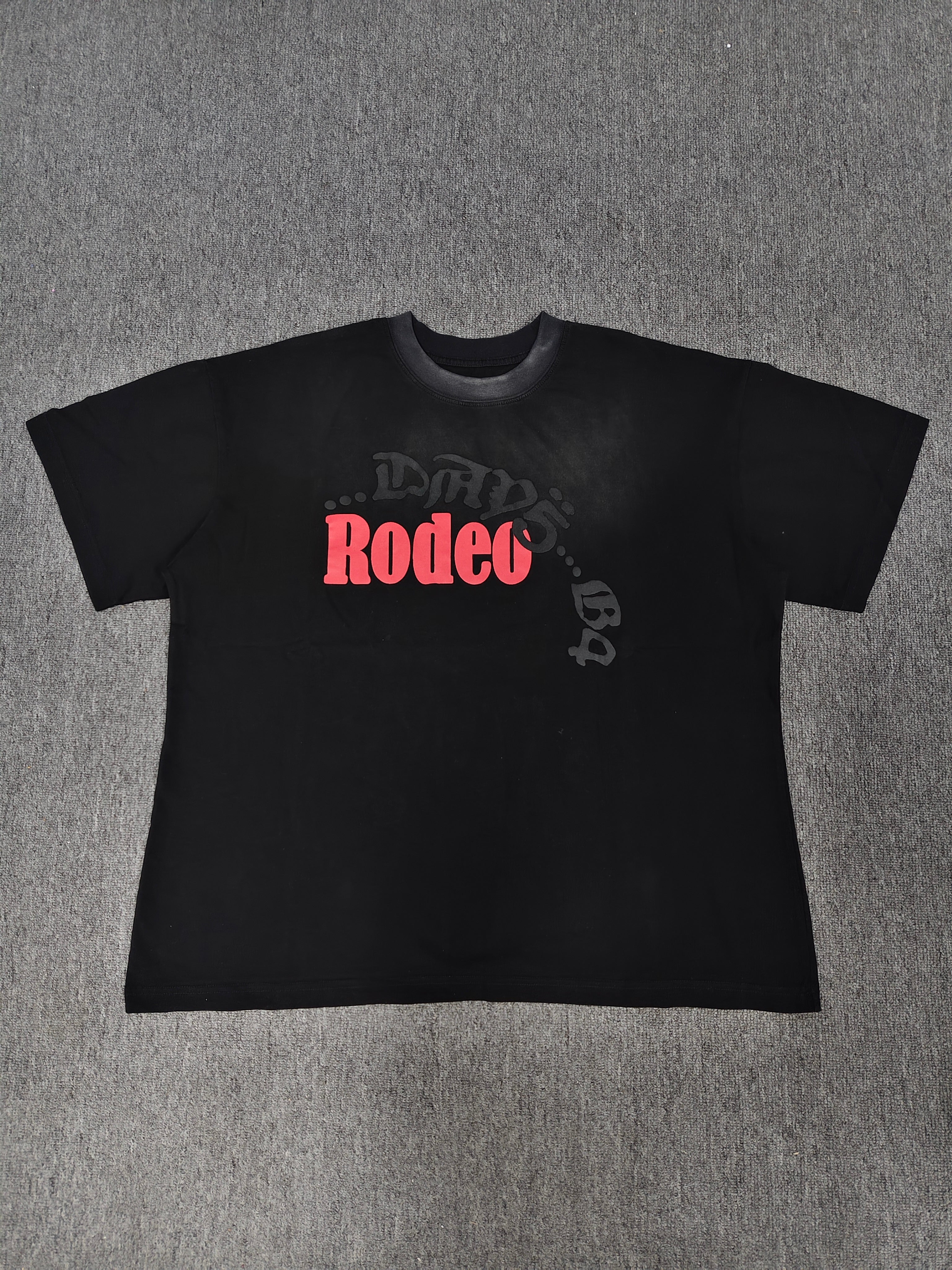 a black Travis Scott x Sp5der "Days Before Rodeo" collaboration t-shirt featuring a distinctive red "Rodeo" graphic and faded branding