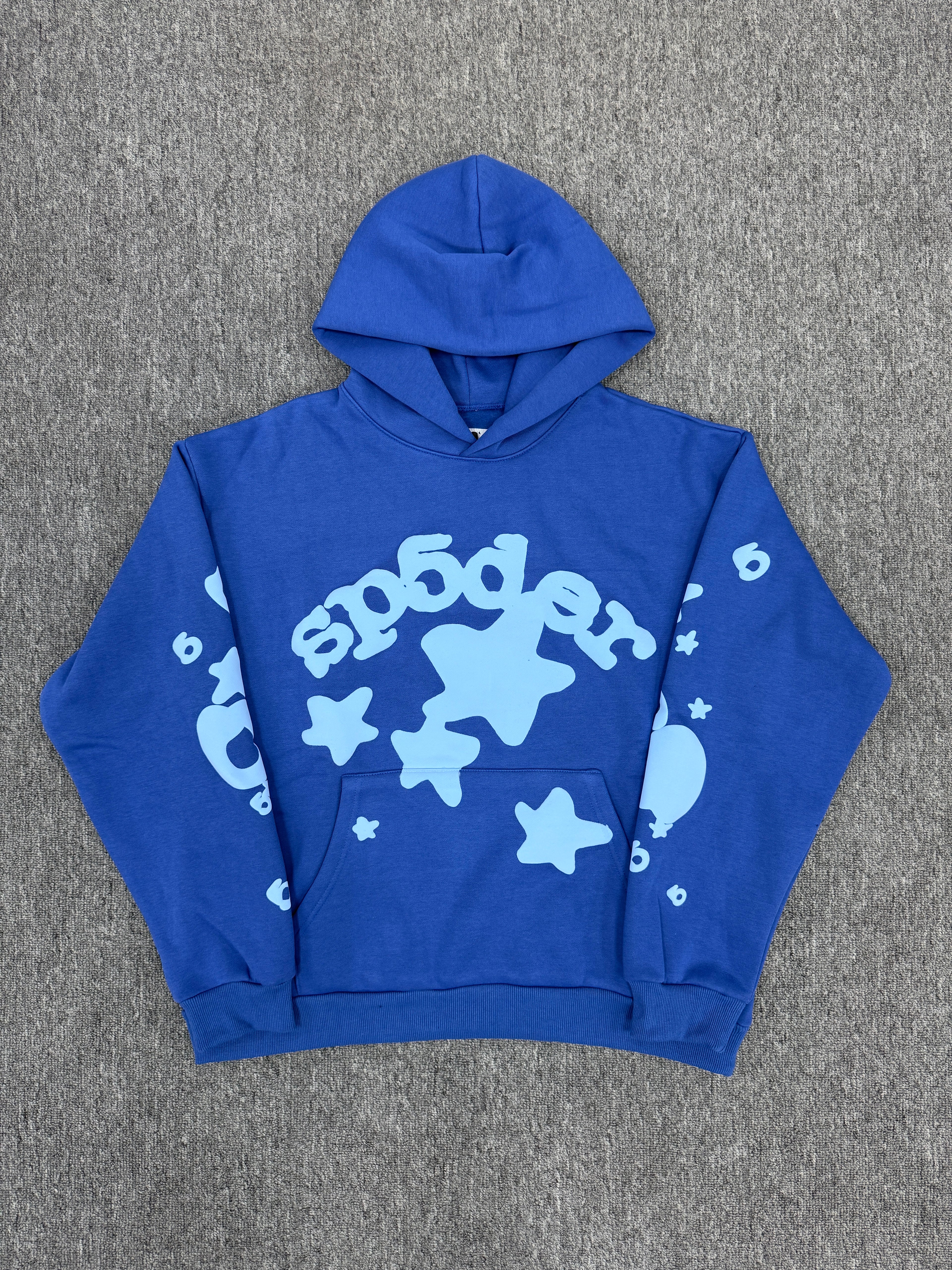 blue Sp5der Beluga hoodie features a distinct light blue graphic print of stars and the brand name on the front and sleeves