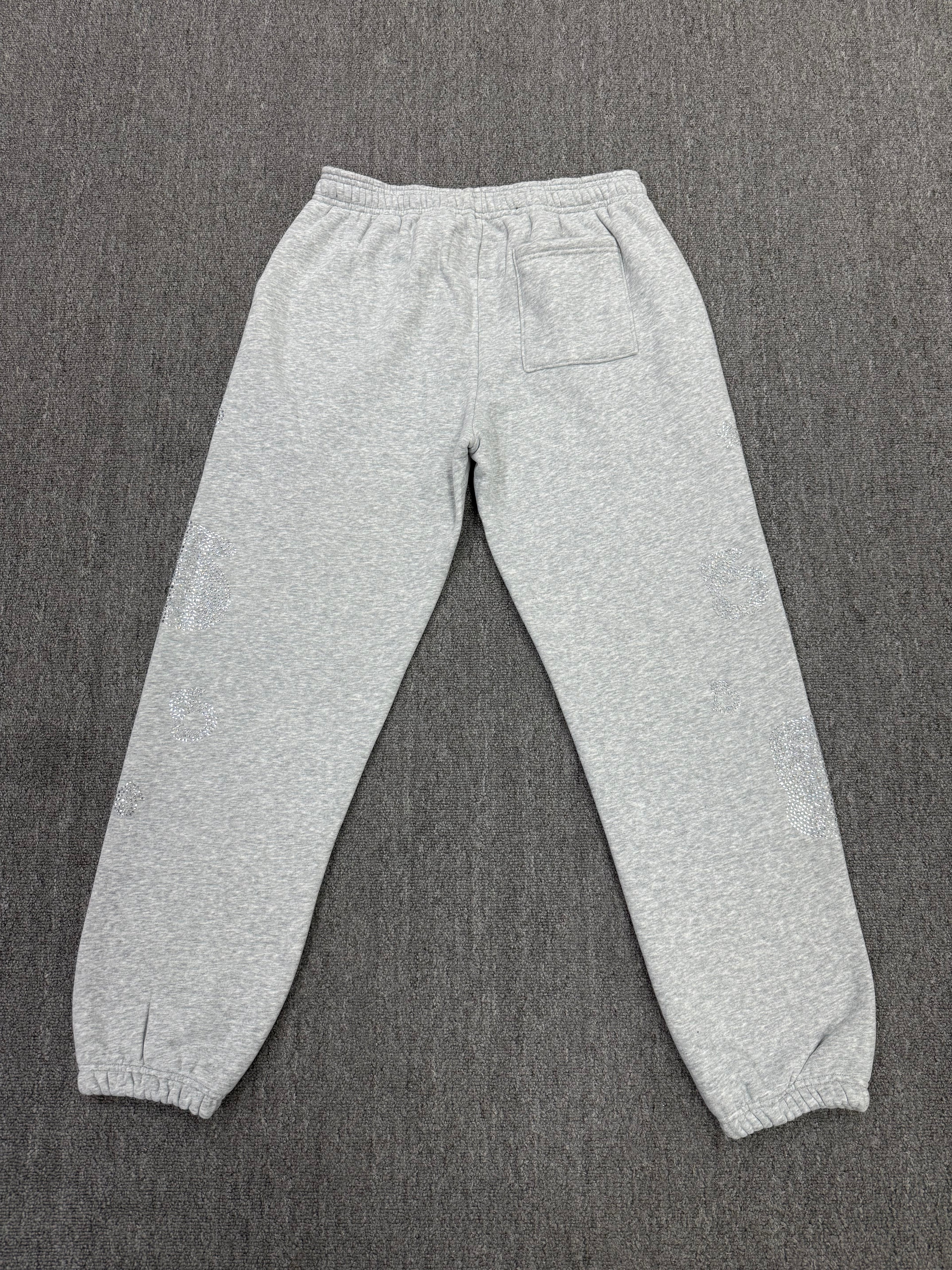 light grey sp5der joggers feature a unique rhinestone across the front hip area