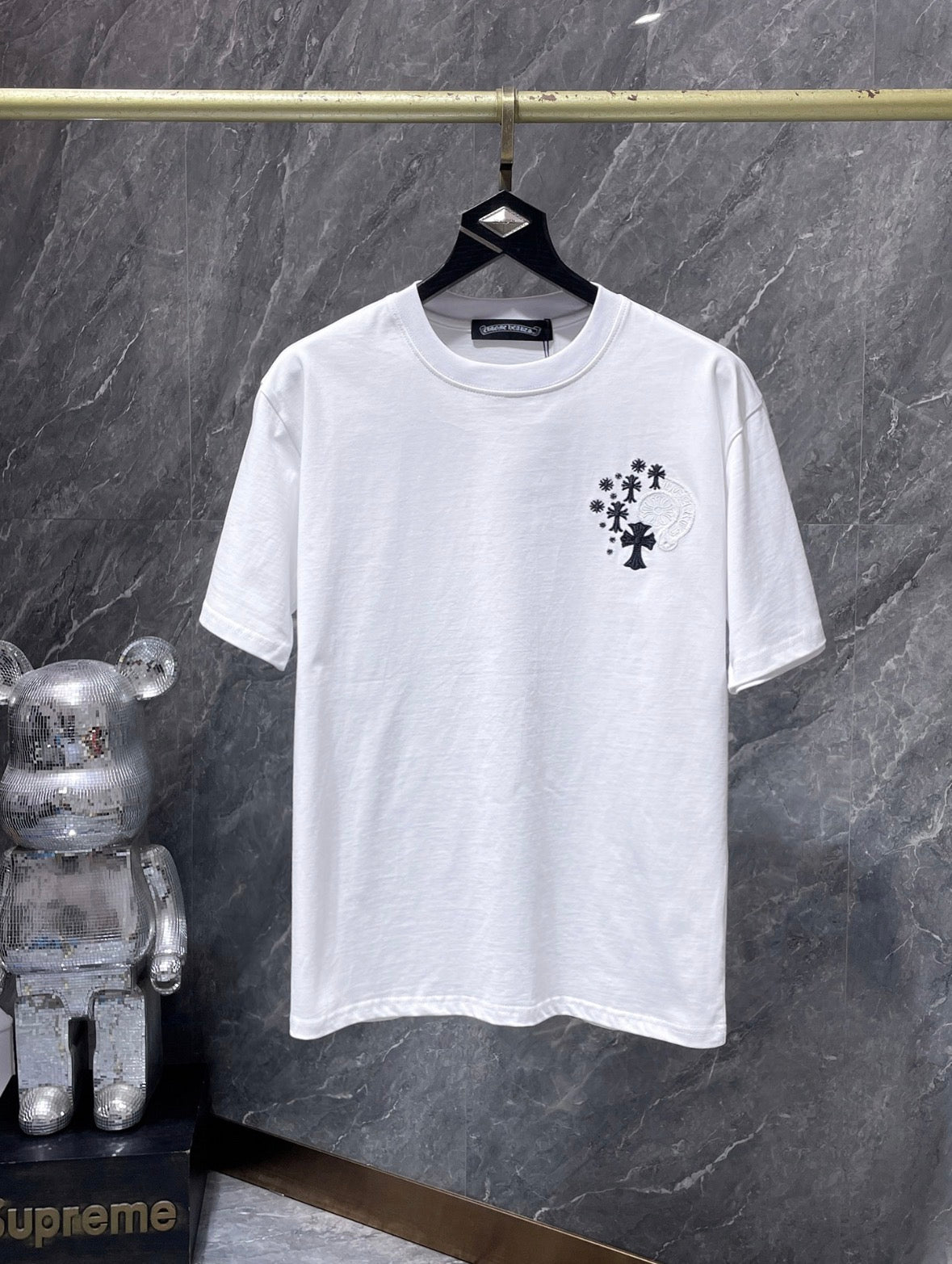 a Chrome Hearts branded short-sleeve t-shirt featuring distinctive embroidered gothic cross and horseshoe graphic details on the back