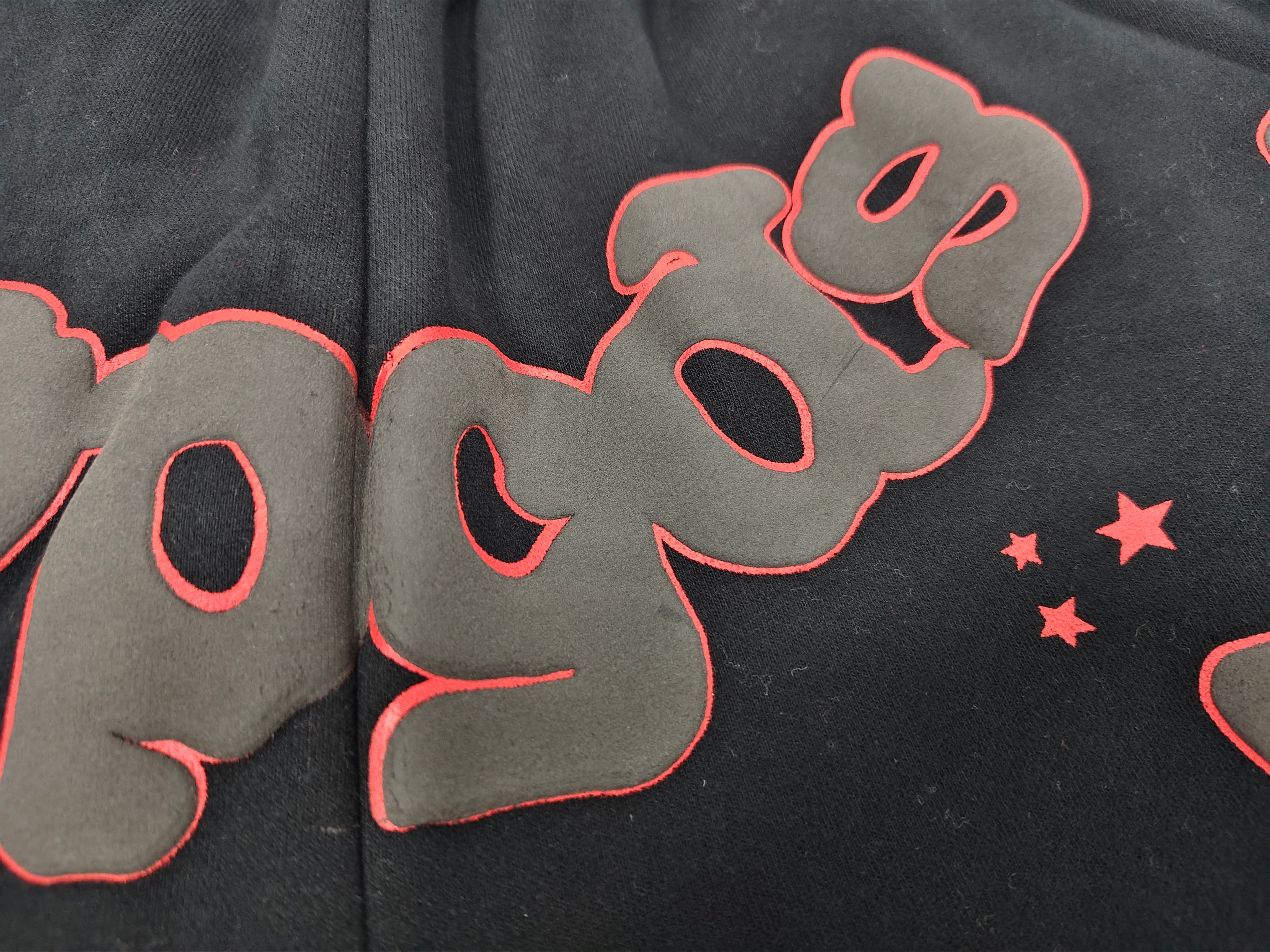 Sp5der Beluga Outline Sweatshorts in black, featuring prominent red-outlined graphic logos and stars