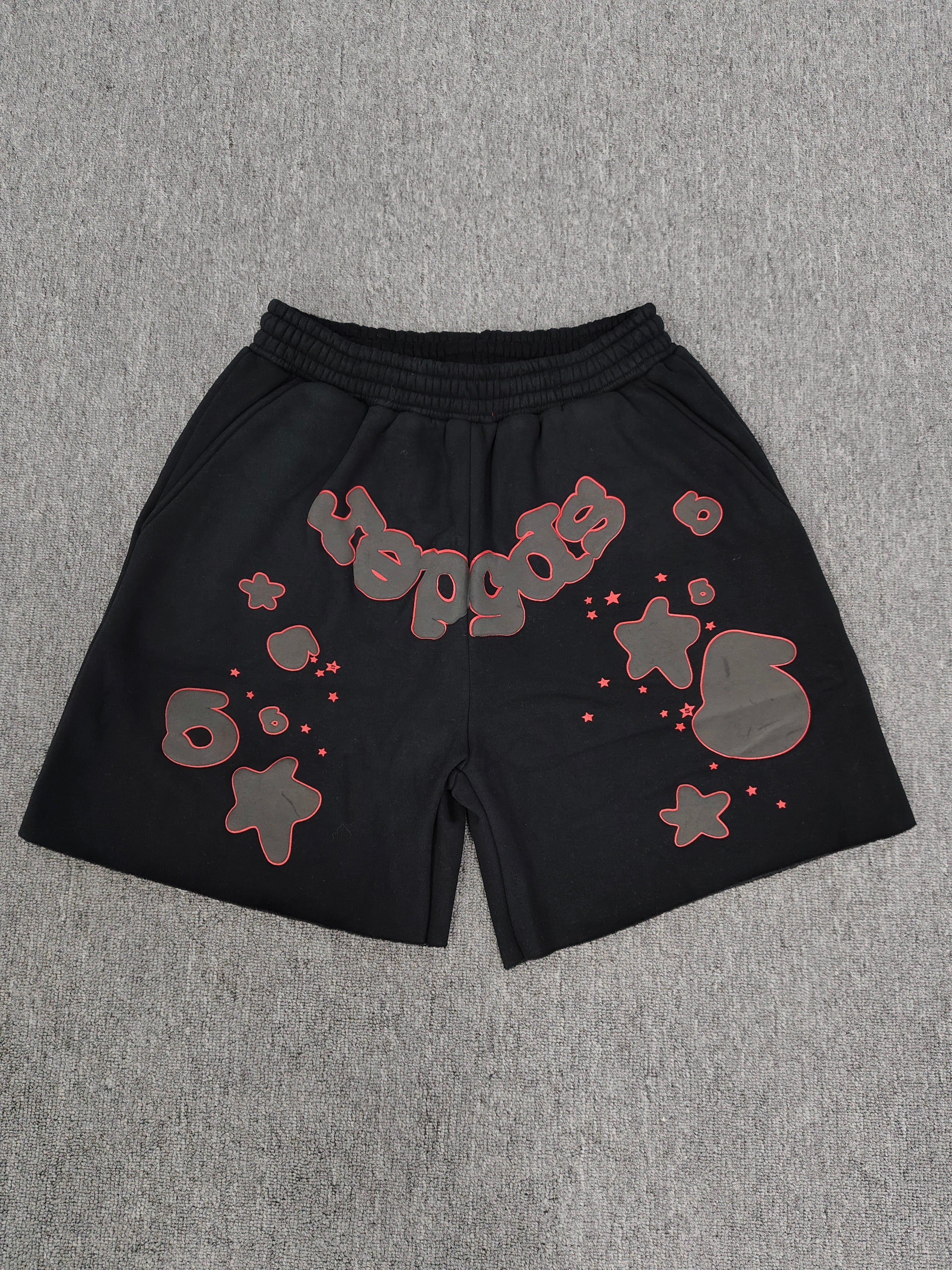 Sp5der Beluga Outline Sweatshorts in black, featuring prominent red-outlined graphic logos and stars