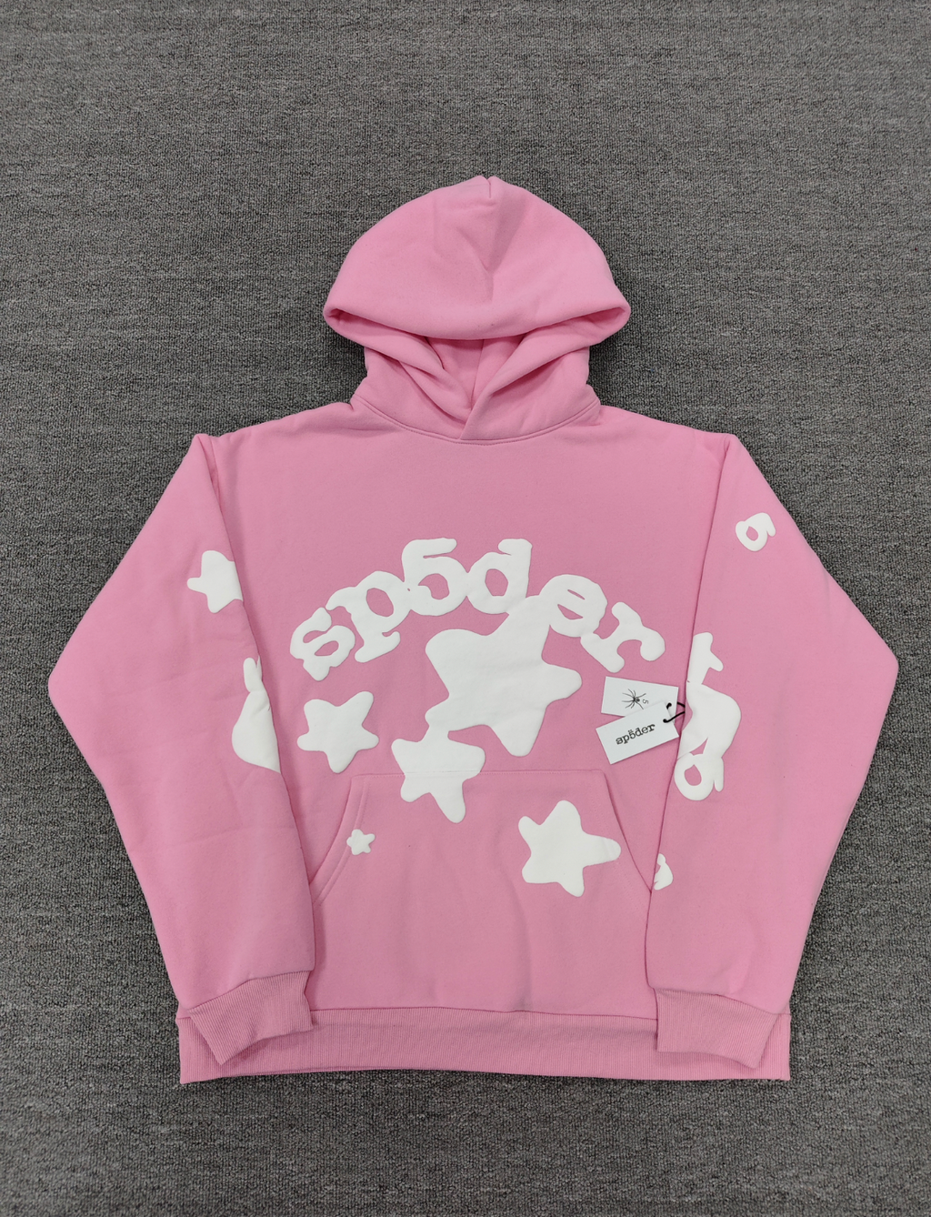 Sp5der pink graphic pullover hoodie features a prominent white screen-printed spiderweb design on the front