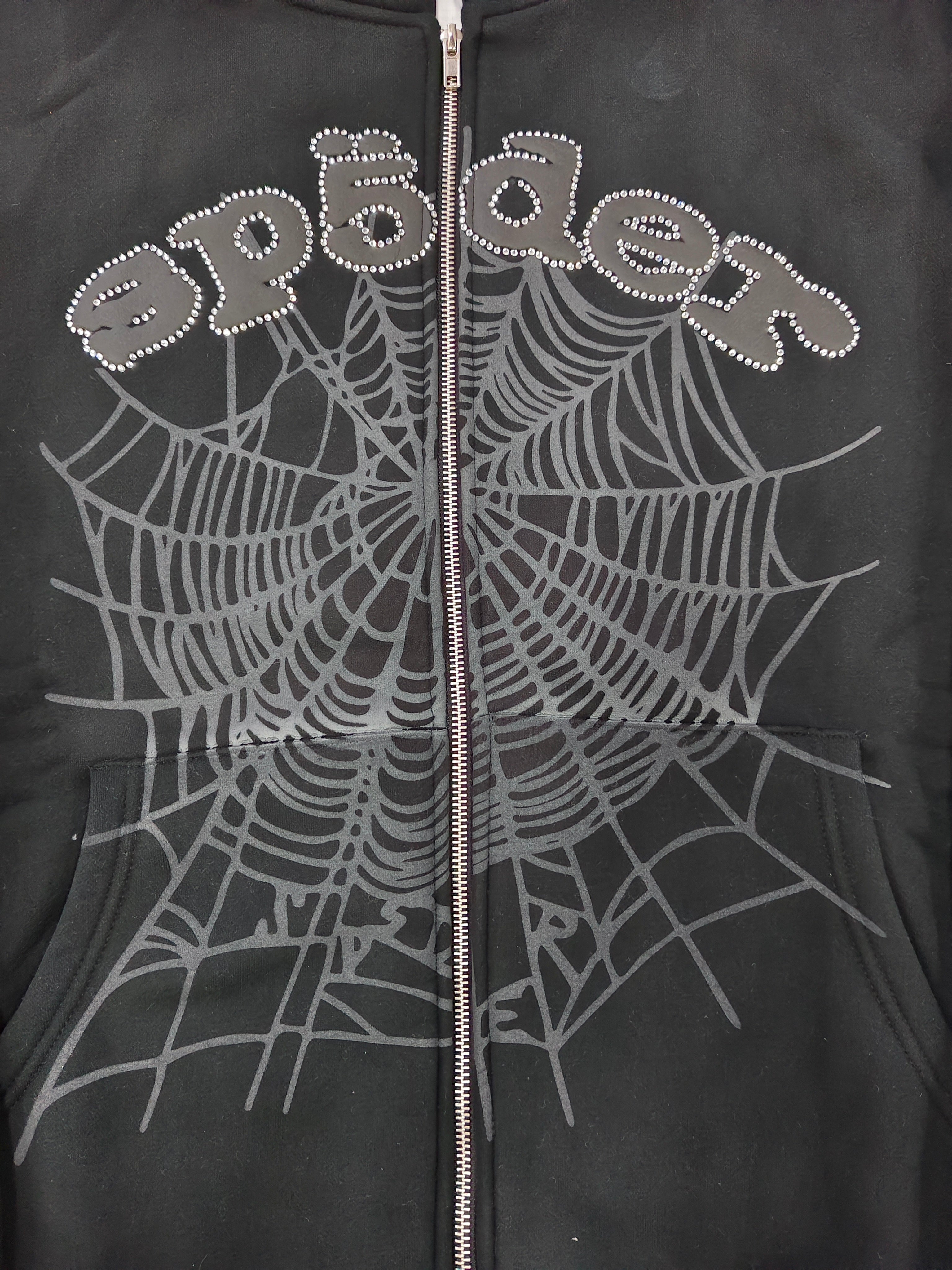 black Sp5der OG Web V2 Phantom Zip Up Hoodie features a prominent rhinestone-embellished logo and web graphic