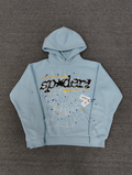 a light blue Sp5der Worldwide hoodie featuring a prominent black graphic logo and a white spiderweb design filled with colorful stars
