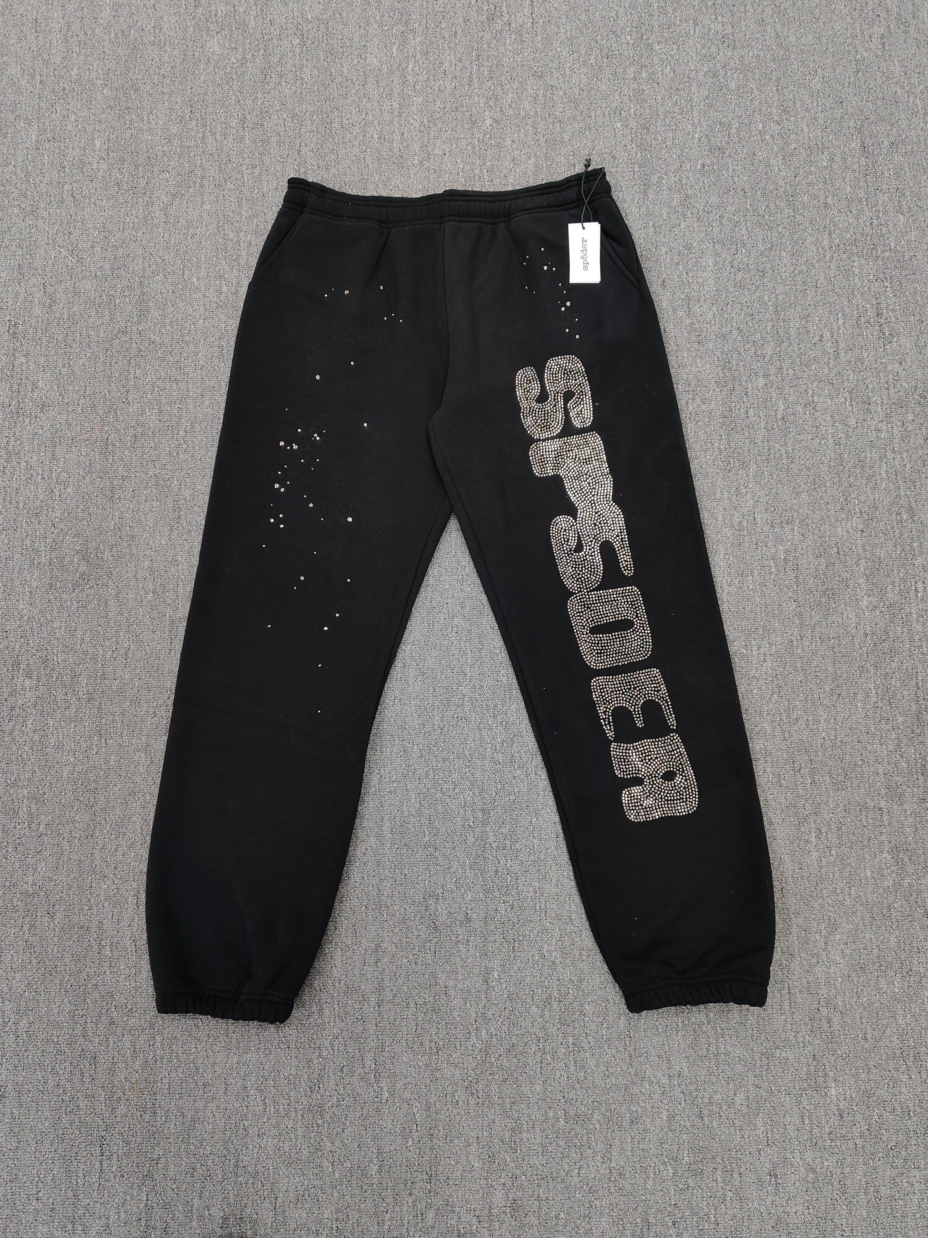 Sp5der Rhinestone Silk sweatpants in black featuring a large rhinestone-embellished logo and scattered star details