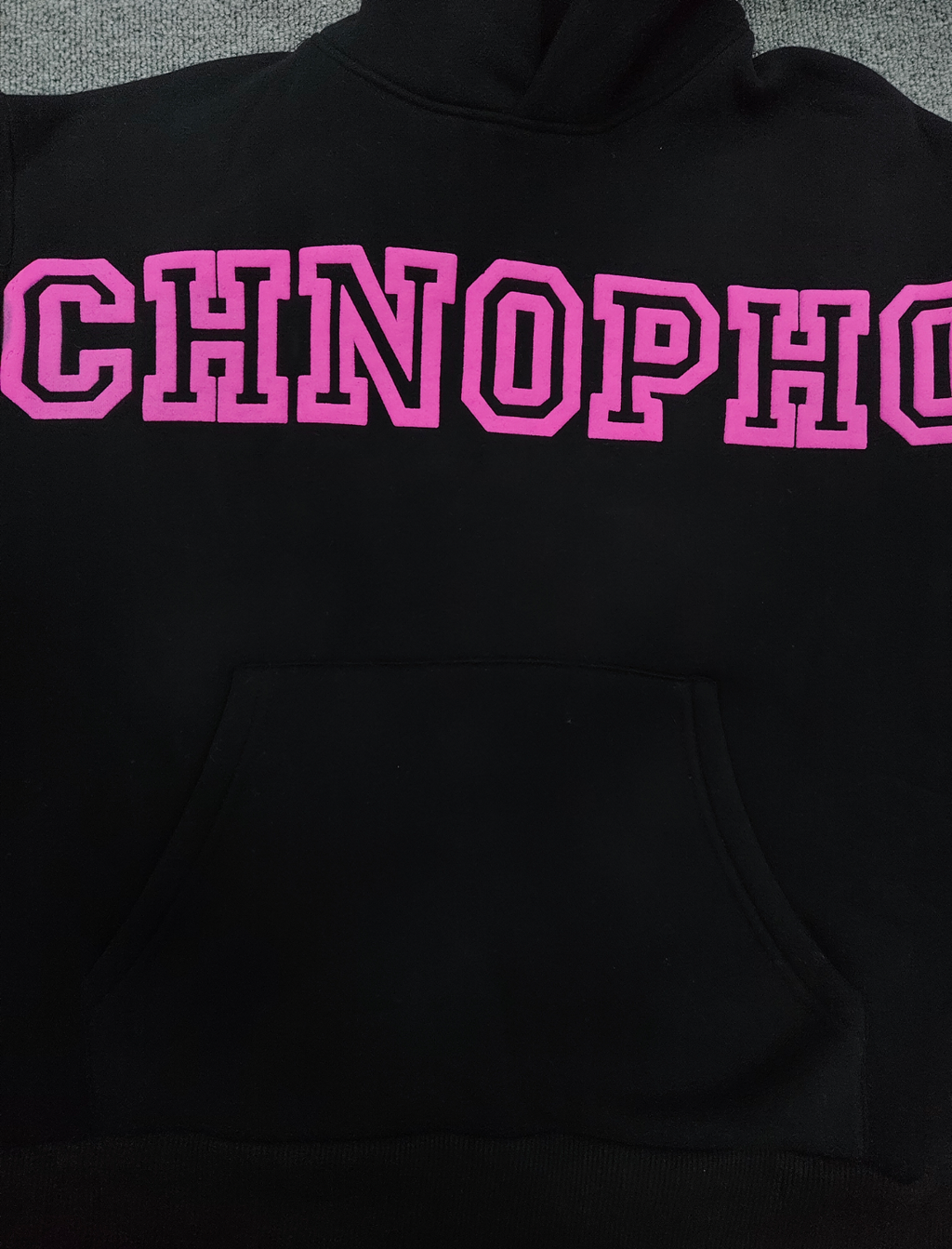 a black Sp5der Arachnophobia hoodie with vibrant pink lettering