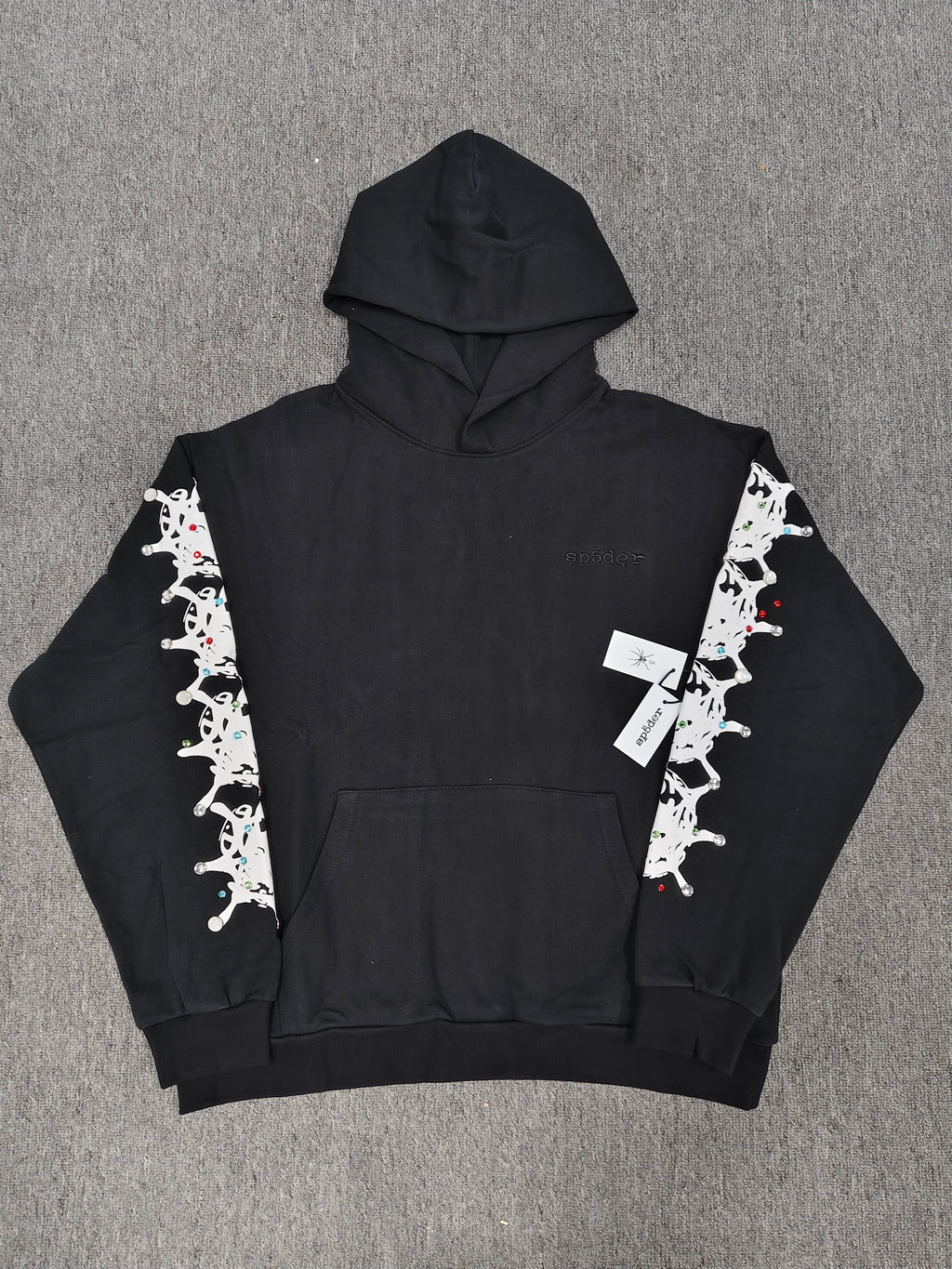 a black Sp5der Stone Hoodie featuring rhinestone embellishments along the sleeves