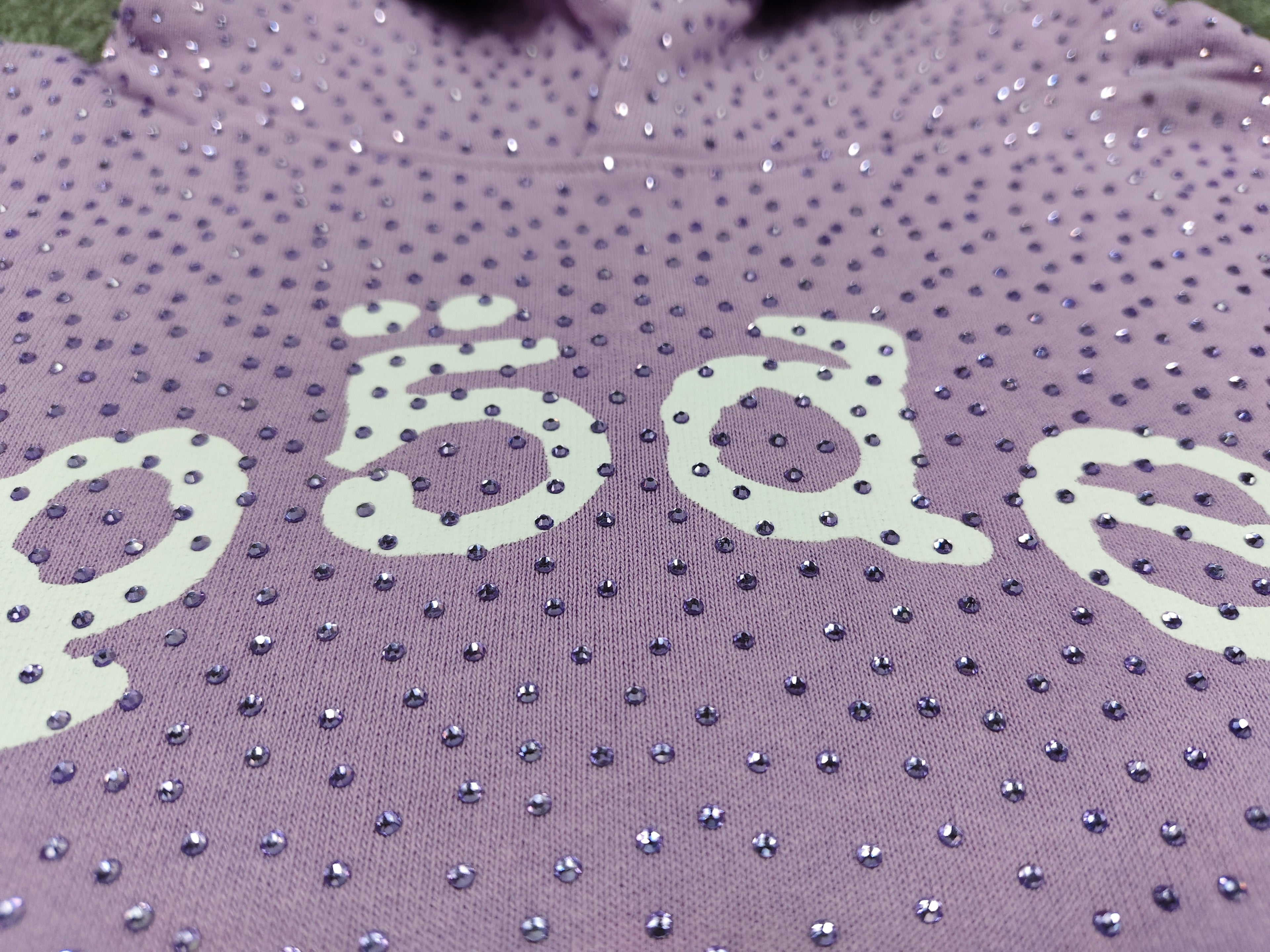 light purple Sp5der rhinestone arch logo hoodie is crafted from cotton fleece and features a glittering finish
