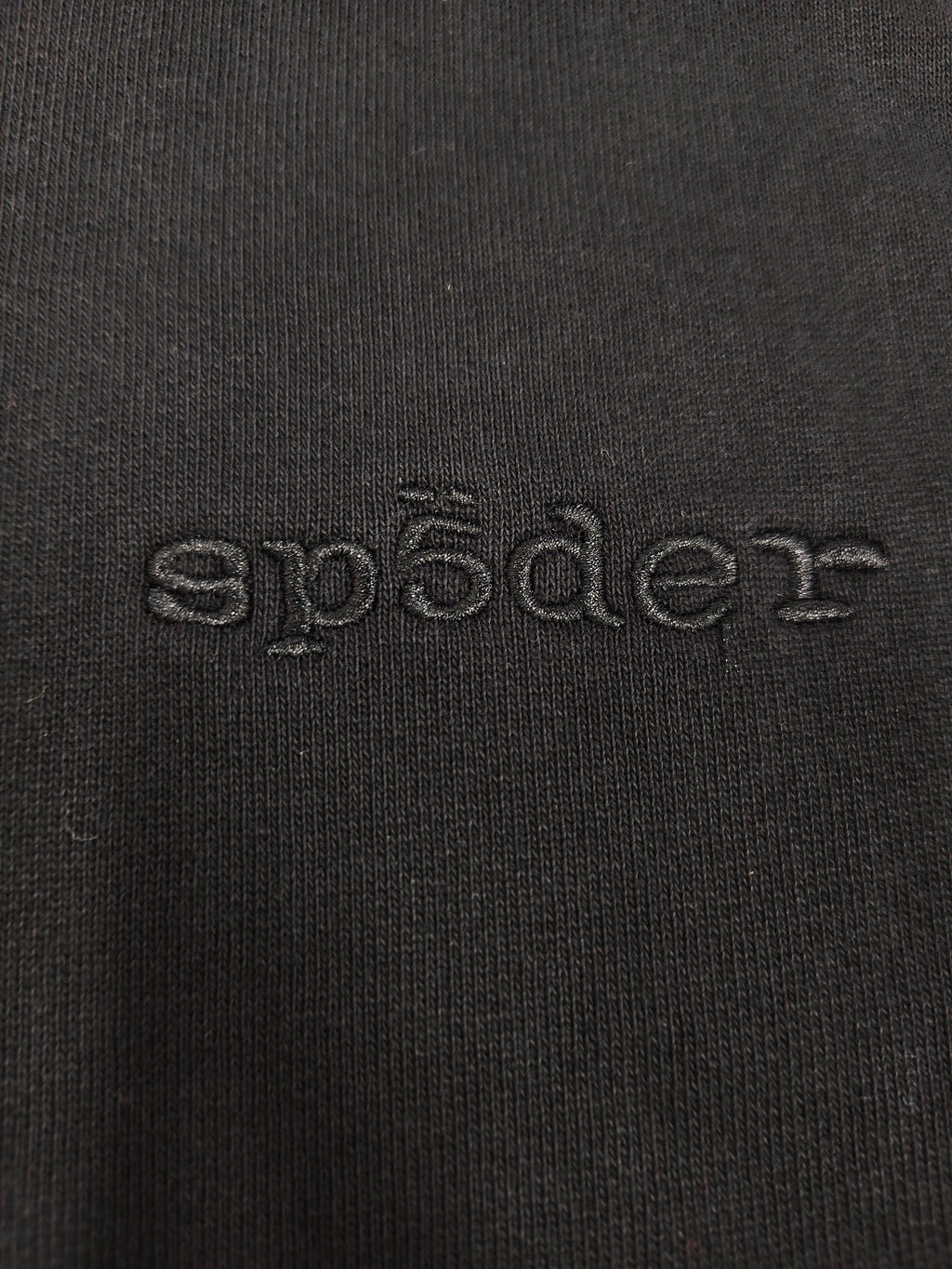 a black Sp5der Stone Hoodie featuring rhinestone embellishments along the sleeves