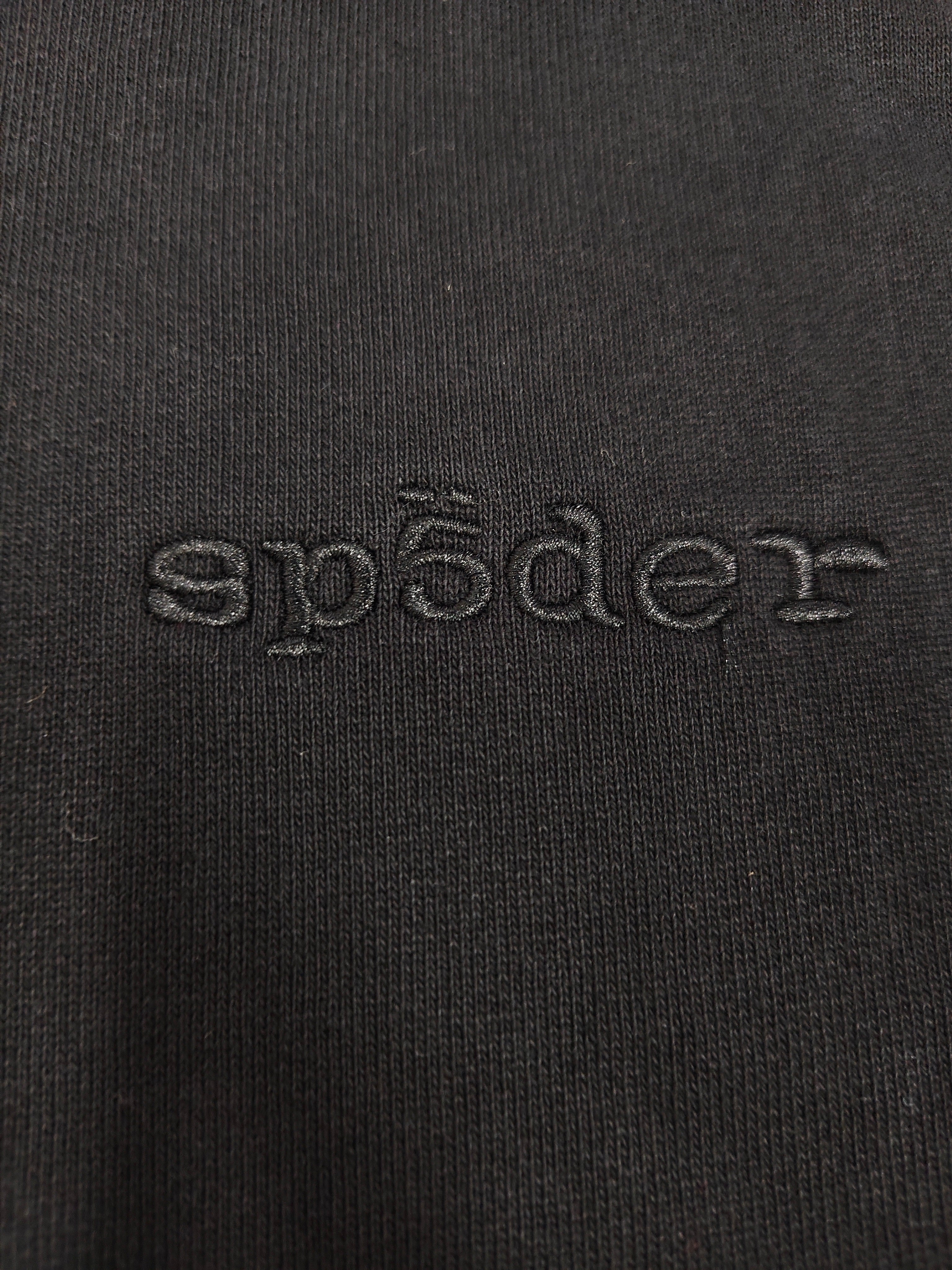 a black Sp5der Stone Hoodie featuring rhinestone embellishments along the sleeves