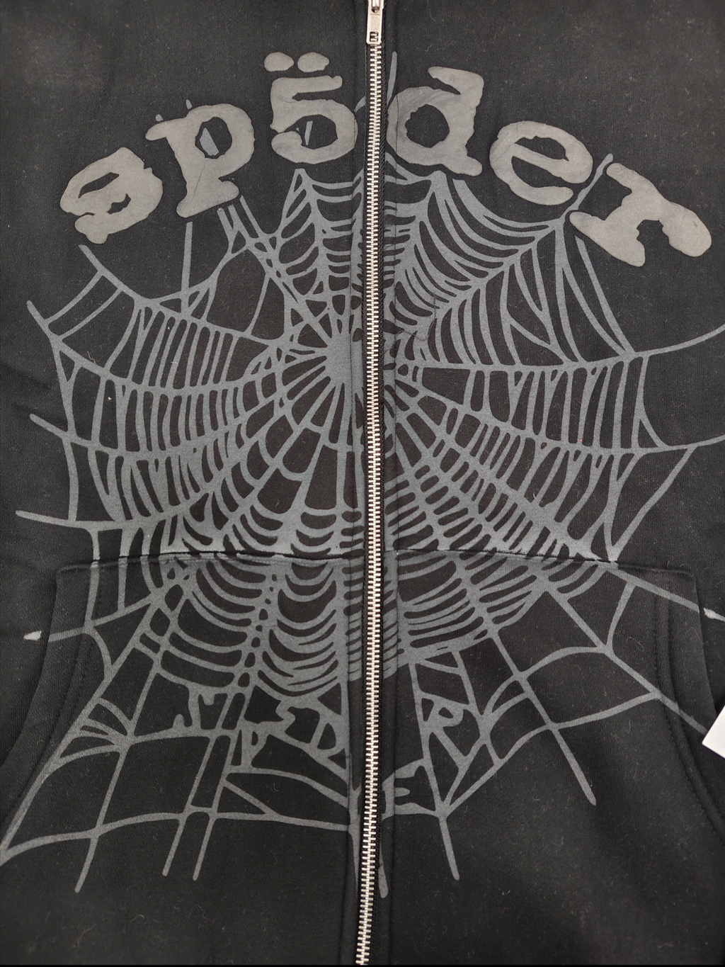 Sp5der OG Web V2 Phantom Zip Up hoodie features a black colorway with a prominent puff-printed web graphic on the front