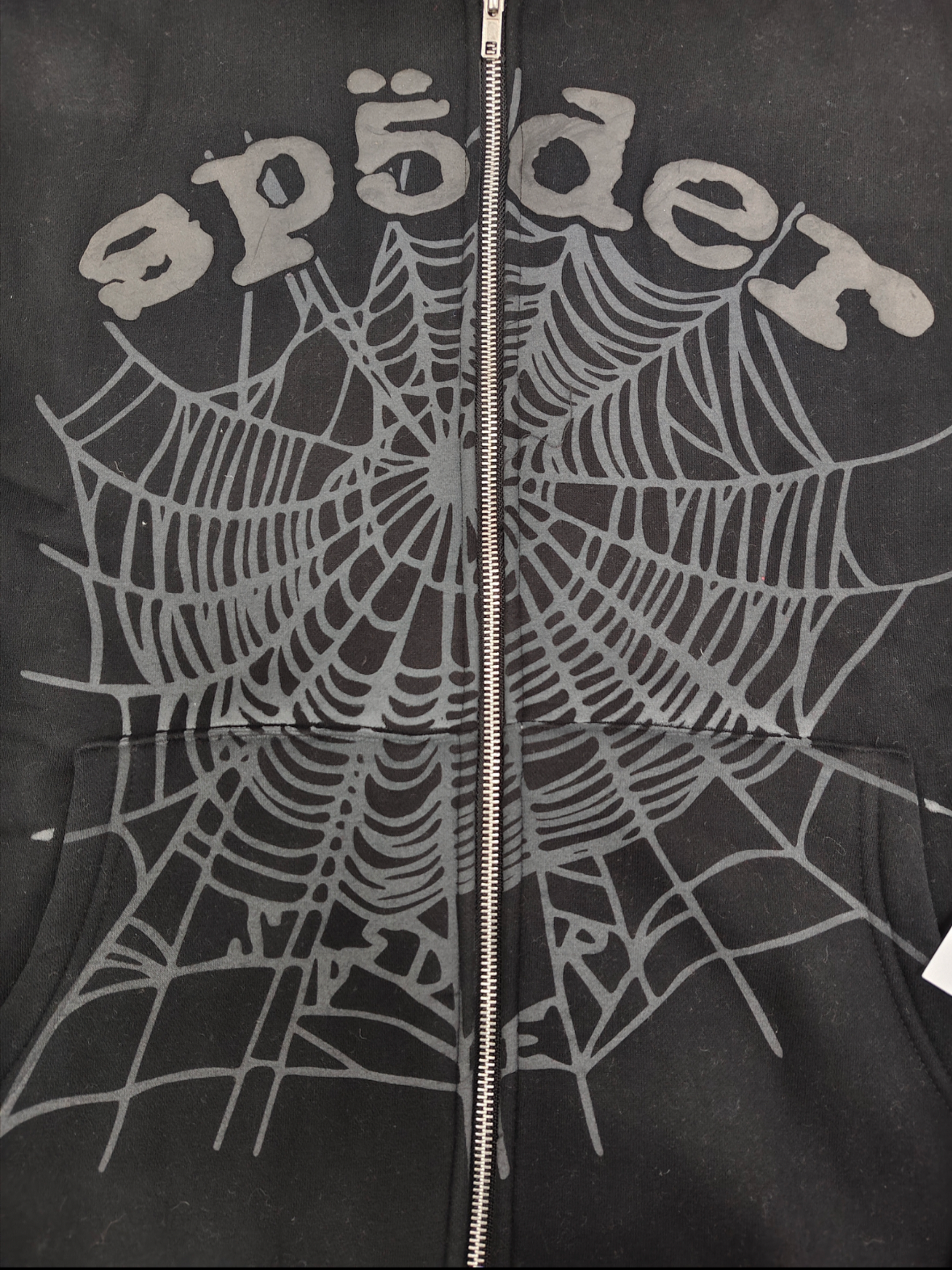 Sp5der OG Web V2 Phantom Zip Up hoodie features a black colorway with a prominent puff-printed web graphic on the front