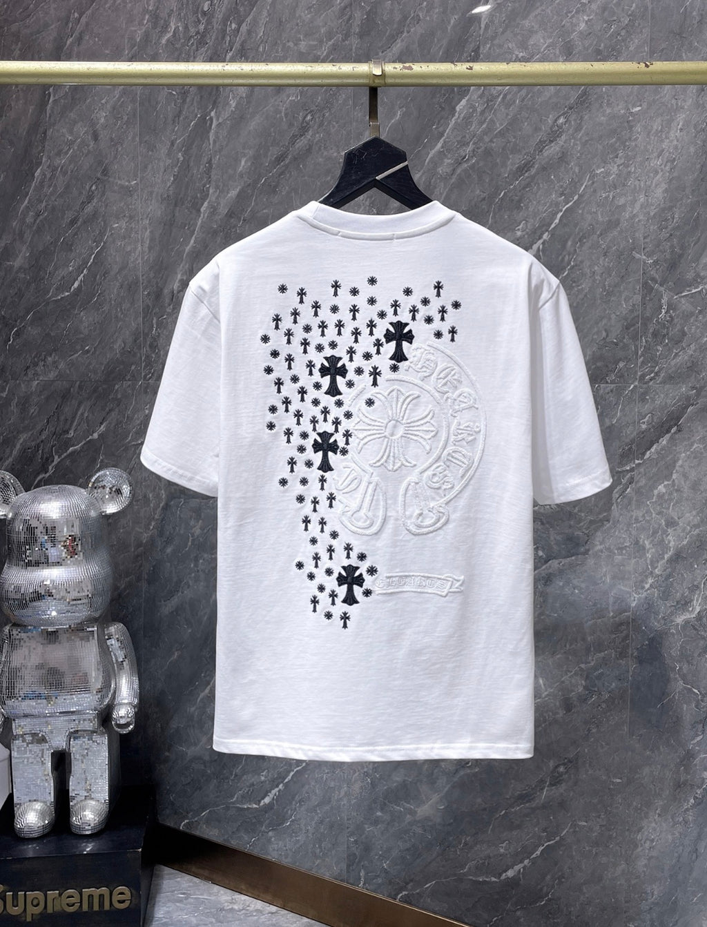 a Chrome Hearts branded short-sleeve t-shirt featuring distinctive embroidered gothic cross and horseshoe graphic details on the back