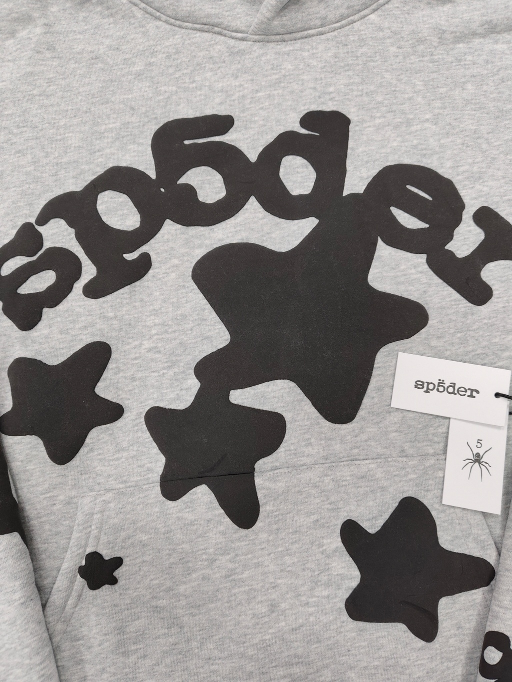 Sp5der Worldwide Beluga hoodie features a distinctive black star graphic across the chest on a light grey heather fabric