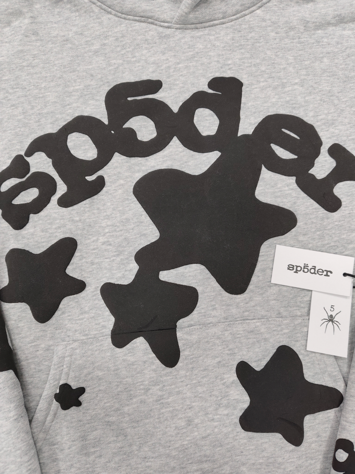 Sp5der Worldwide Beluga hoodie features a distinctive black star graphic across the chest on a light grey heather fabric
