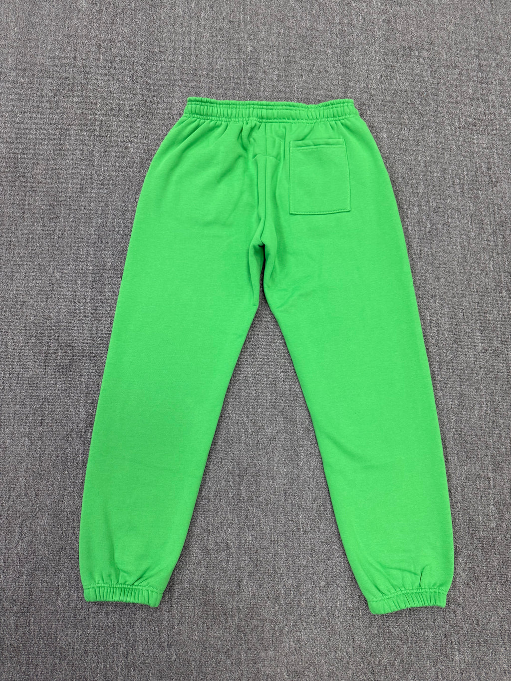 Sp5der Punk V2 Rhinestone track pants in green, featuring prominent black rhinestone-lined graphics and stars