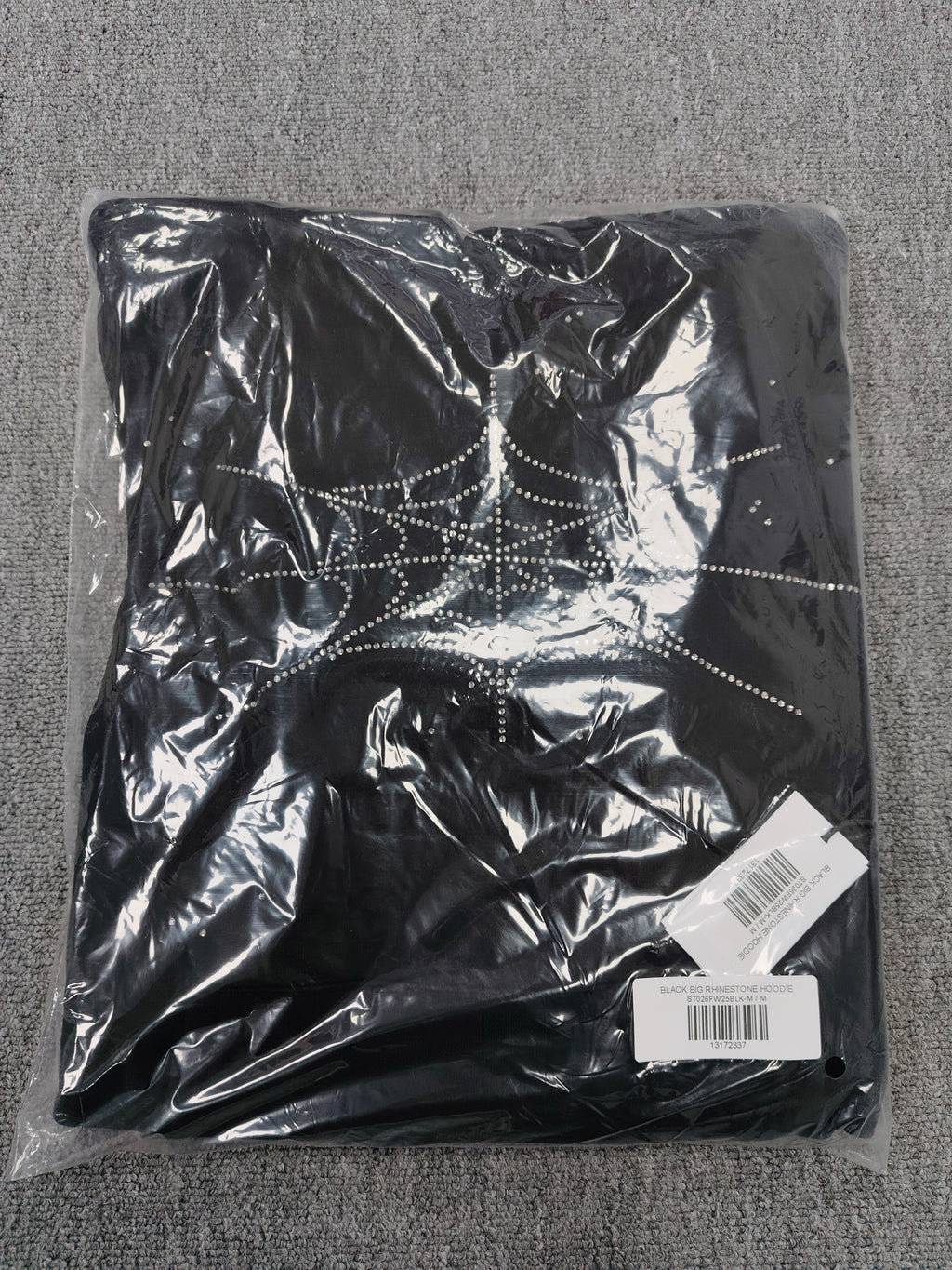 a Sp5der Rhinestone Silk Hoodie in black, featuring a prominent rhinestone web graphic on the front