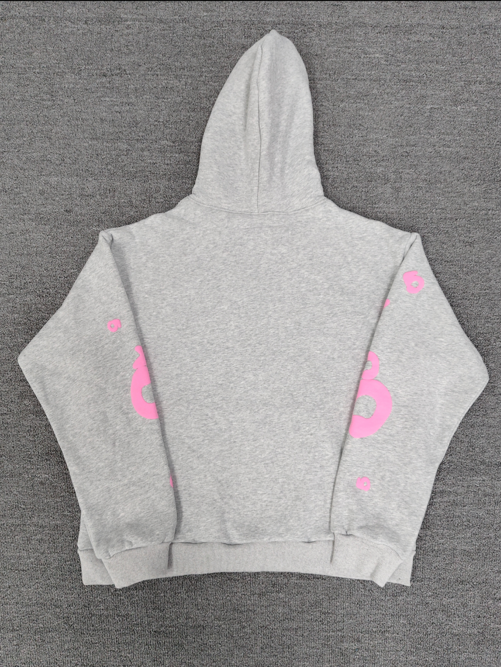 a grey Sp5der "Beluga" hoodie featuring pink star graphics and brand lettering