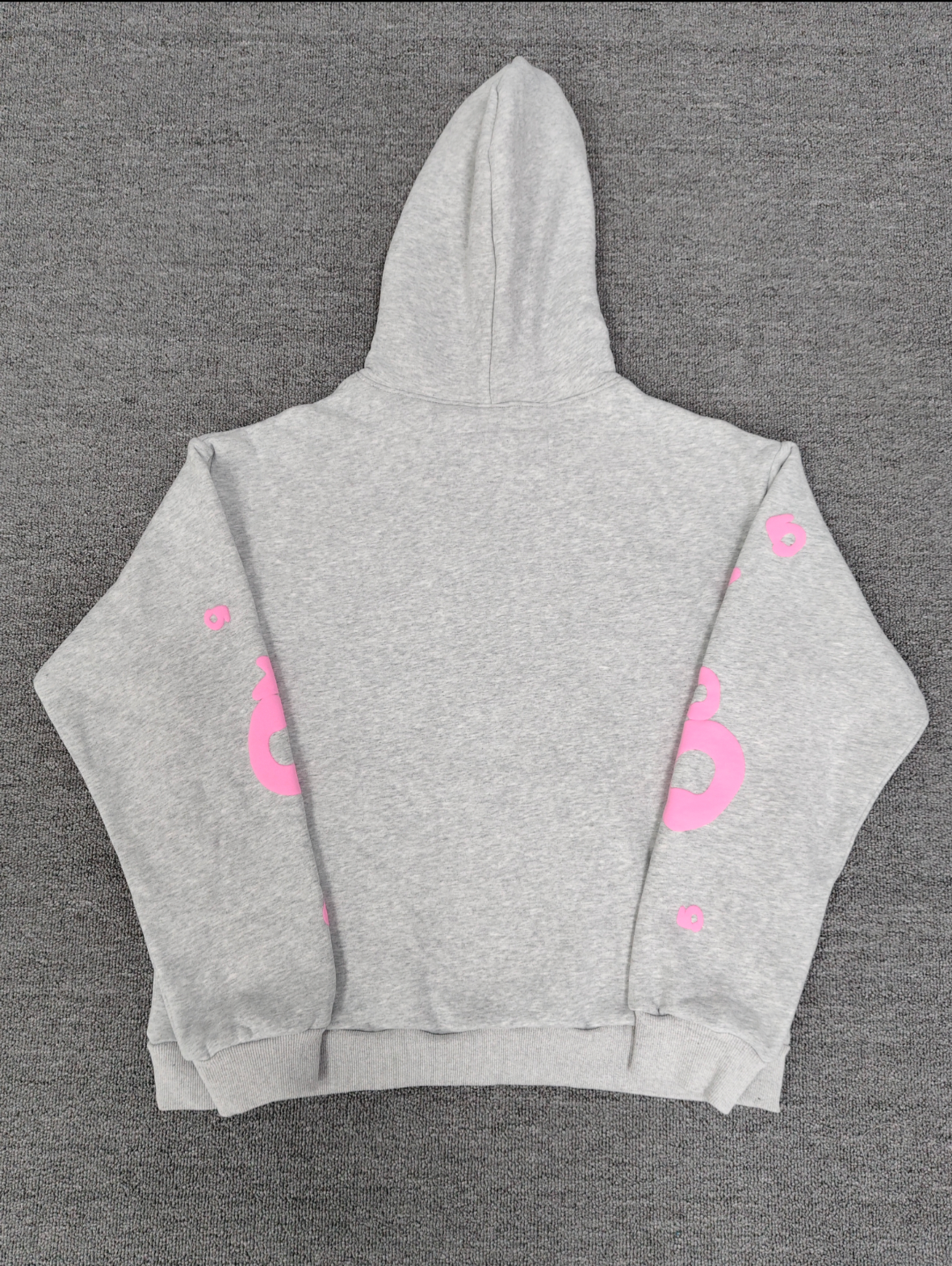 a grey Sp5der "Beluga" hoodie featuring pink star graphics and brand lettering