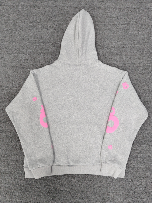 a grey Sp5der "Beluga" hoodie featuring pink star graphics and brand lettering
