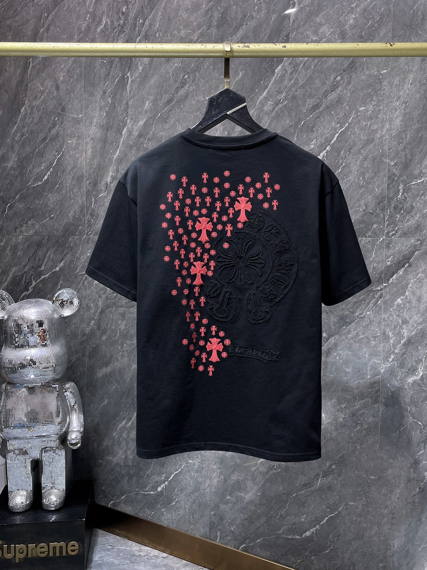 a Chrome Hearts branded short-sleeve t-shirt featuring distinctive embroidered gothic cross and horseshoe graphic details on the back